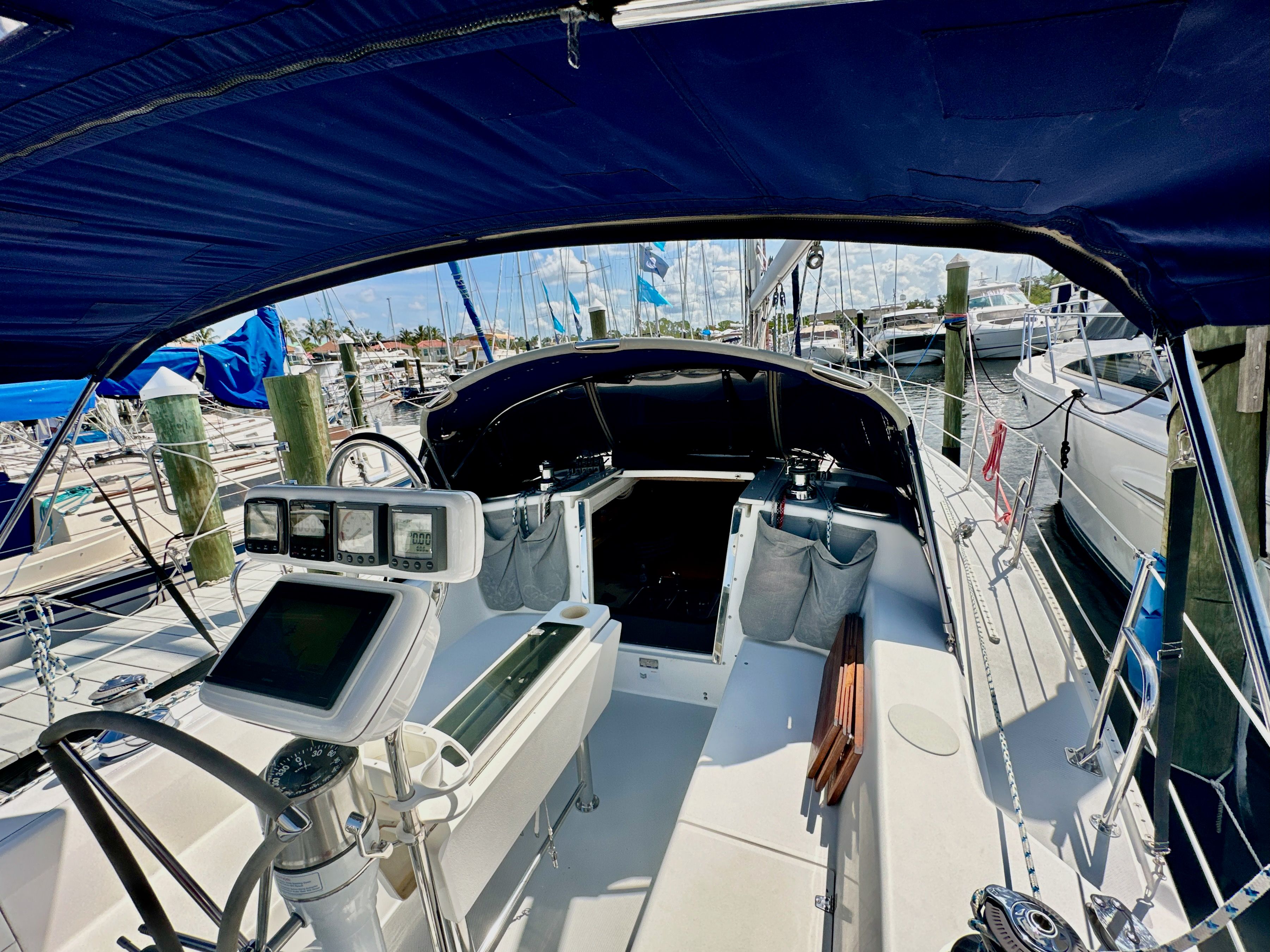2005 Catalina 36 sailboat cockpit with navigation equipment, docked at a marina under a blue canopy.