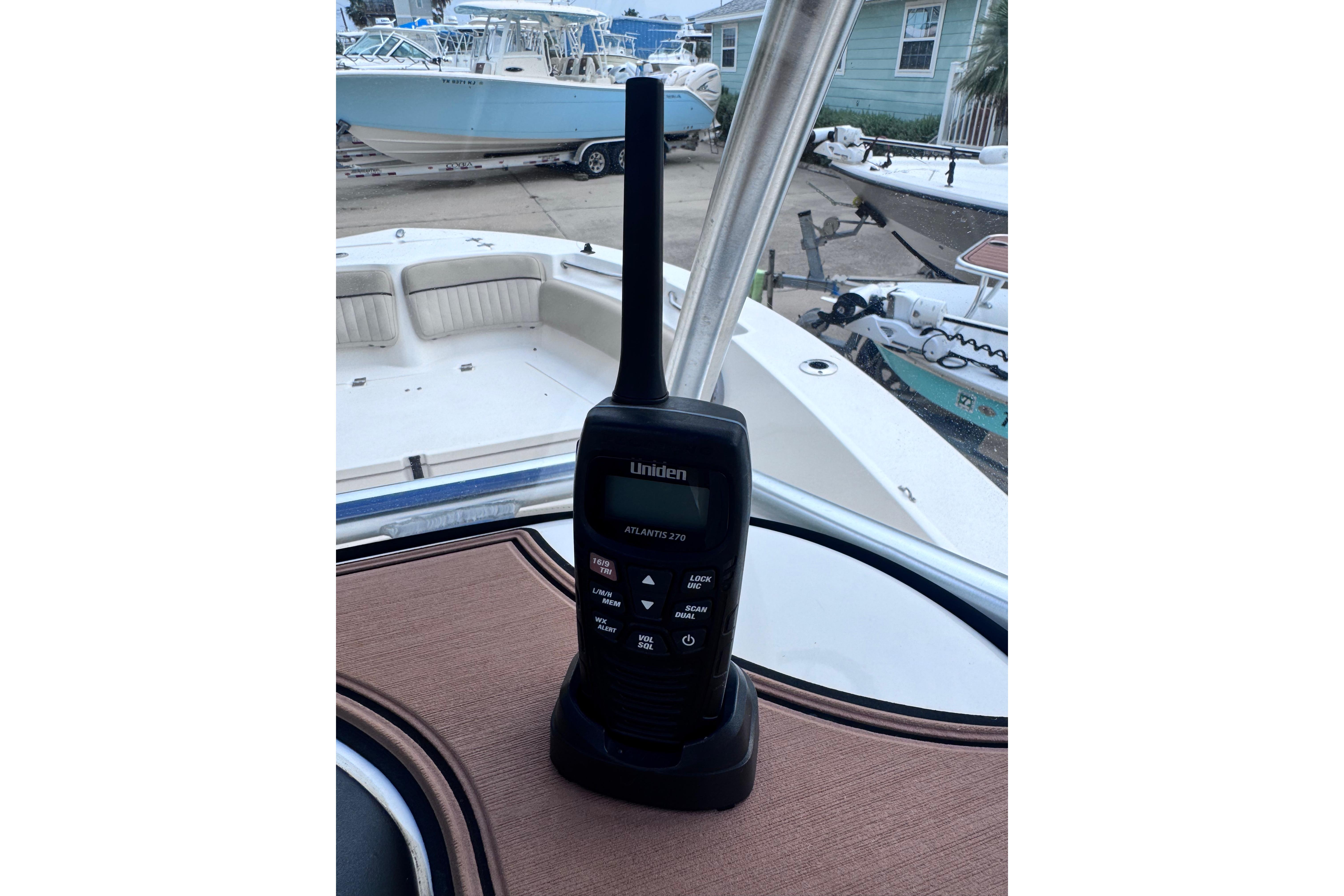 Handheld radio on 2018 Sea Fox 206 Commander boat deck, marina background.