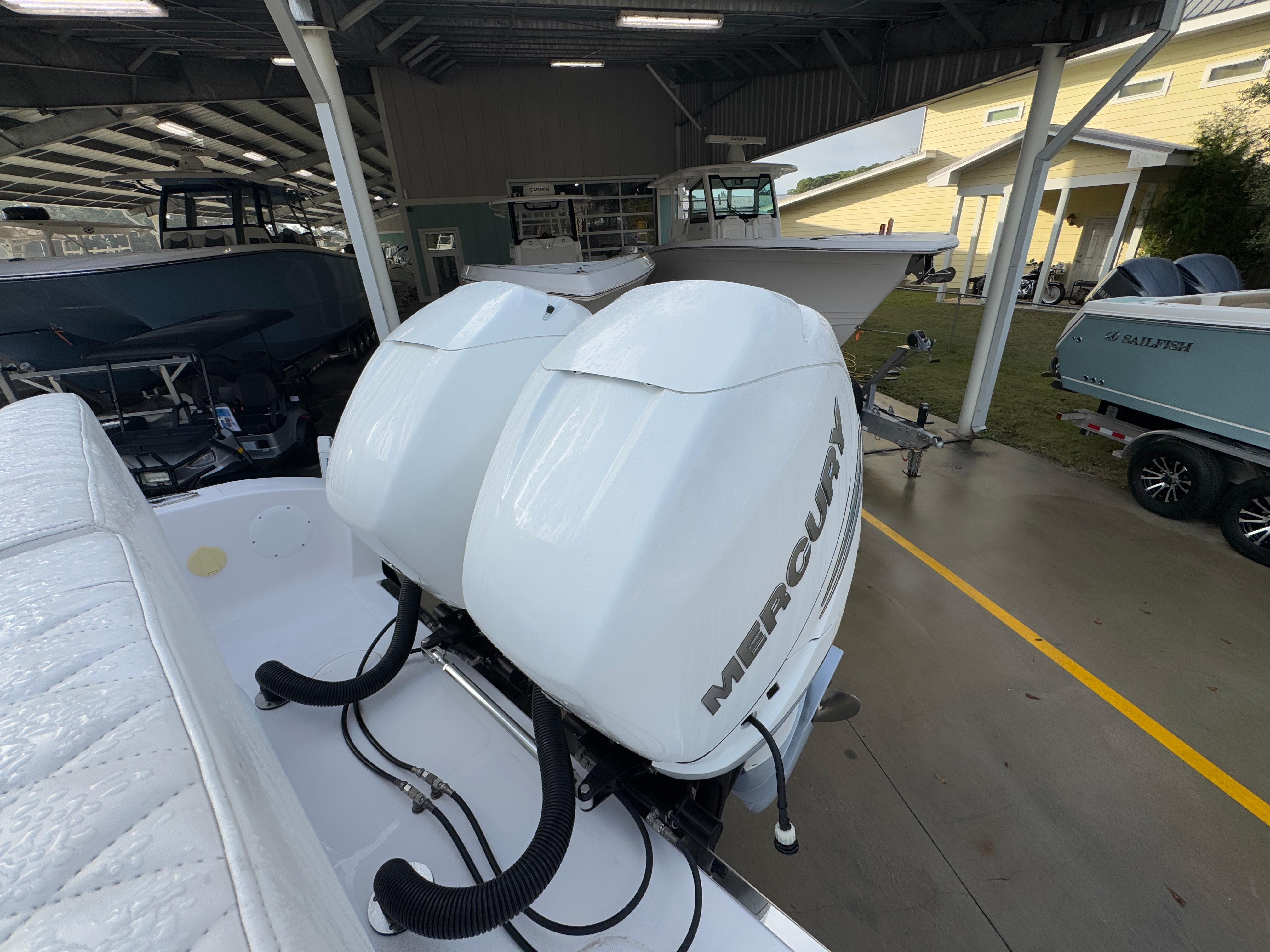 2018 Fountain 34 CC boat with dual Mercury outboard engines in a covered marina.