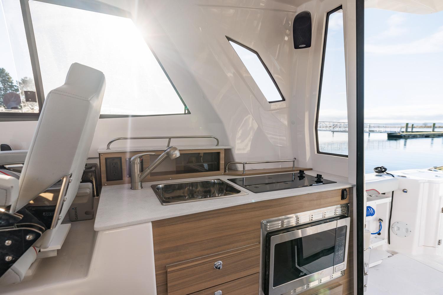 Modern kitchen area on 2026 Solara S-310 SB boat with sink and stove.