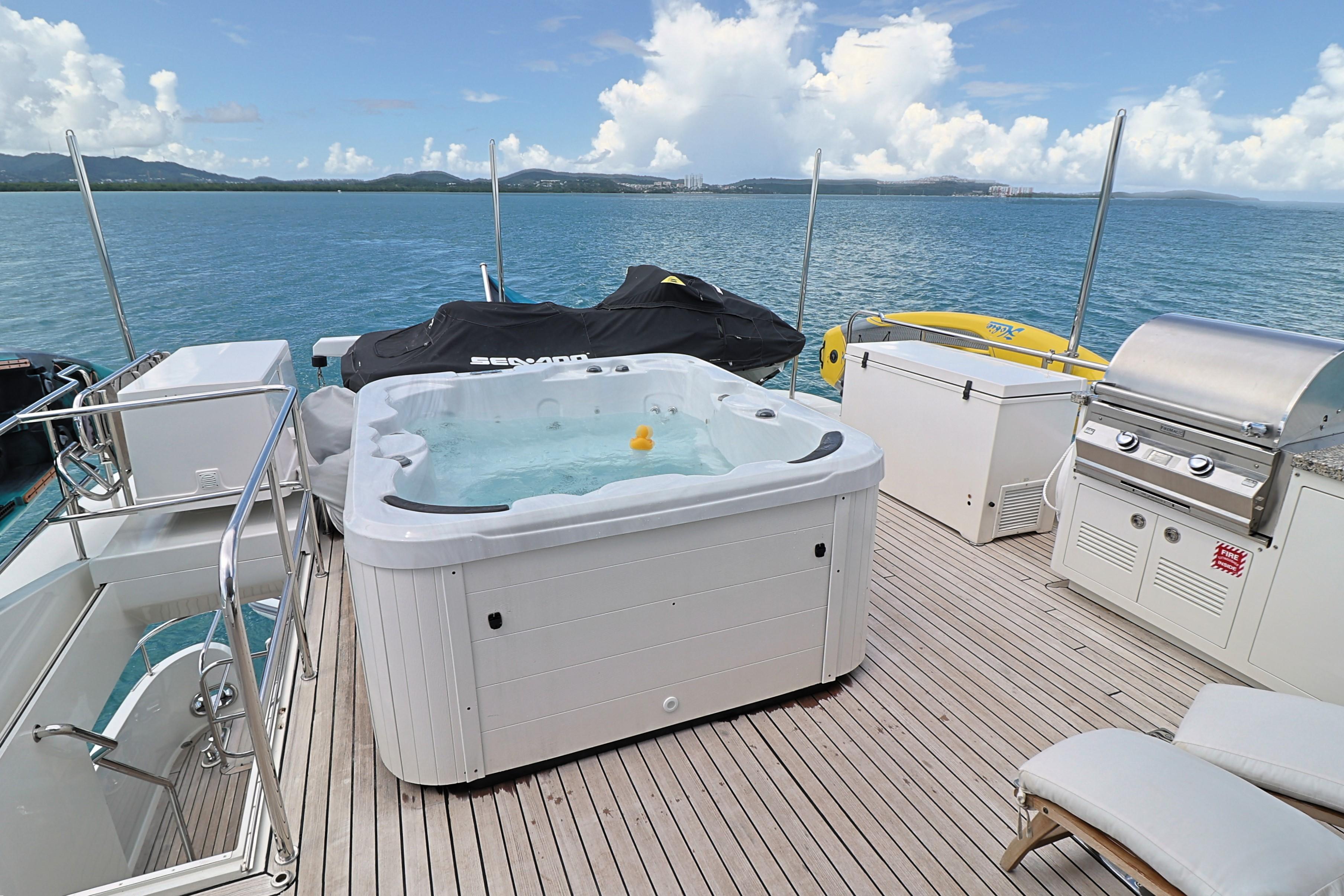 Luxurious 2013 Cheoy Lee Bravo yacht deck with hot tub, grill, and ocean view.