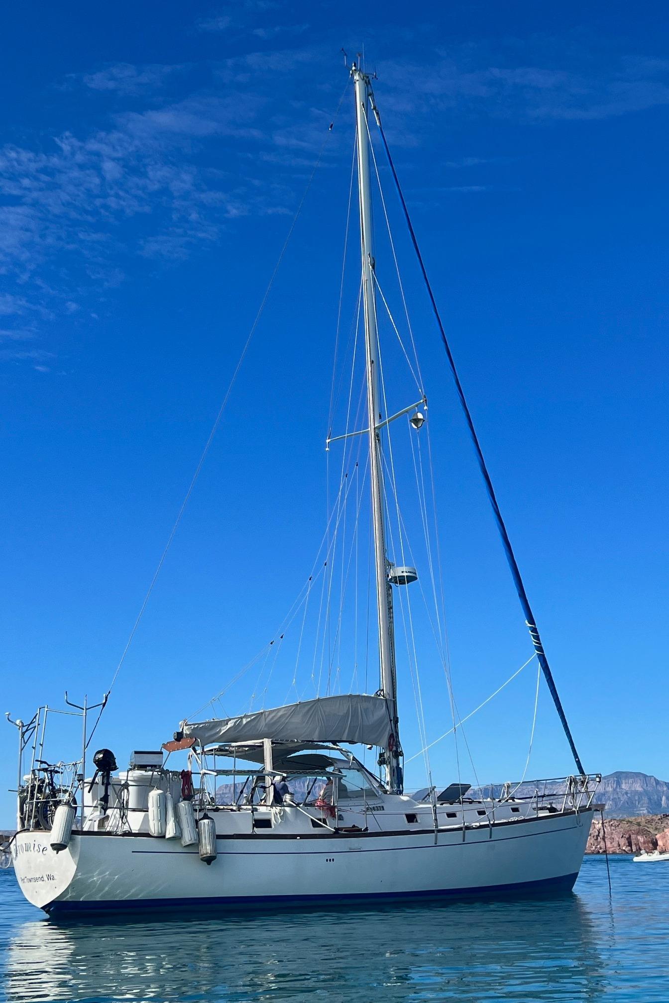 1979 Morgan 461 sailboat anchored on calm water under clear blue sky.