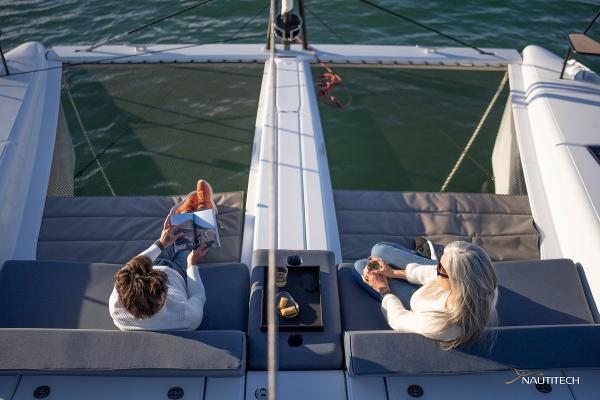 Two people relaxing on a 2025 Nautitech 48 Open catamaran deck.