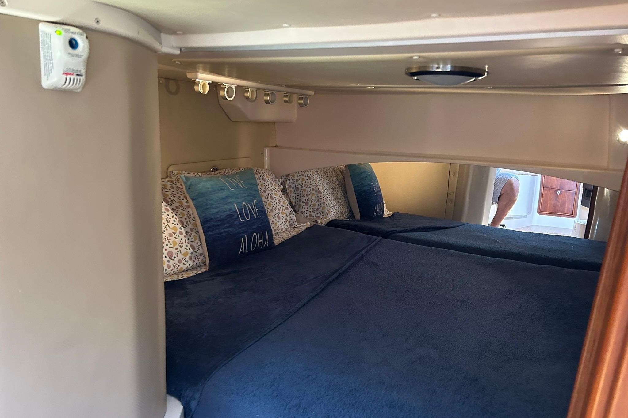 Interior cabin of 2007 Grady-White Express 360 with cozy bedding and pillows.