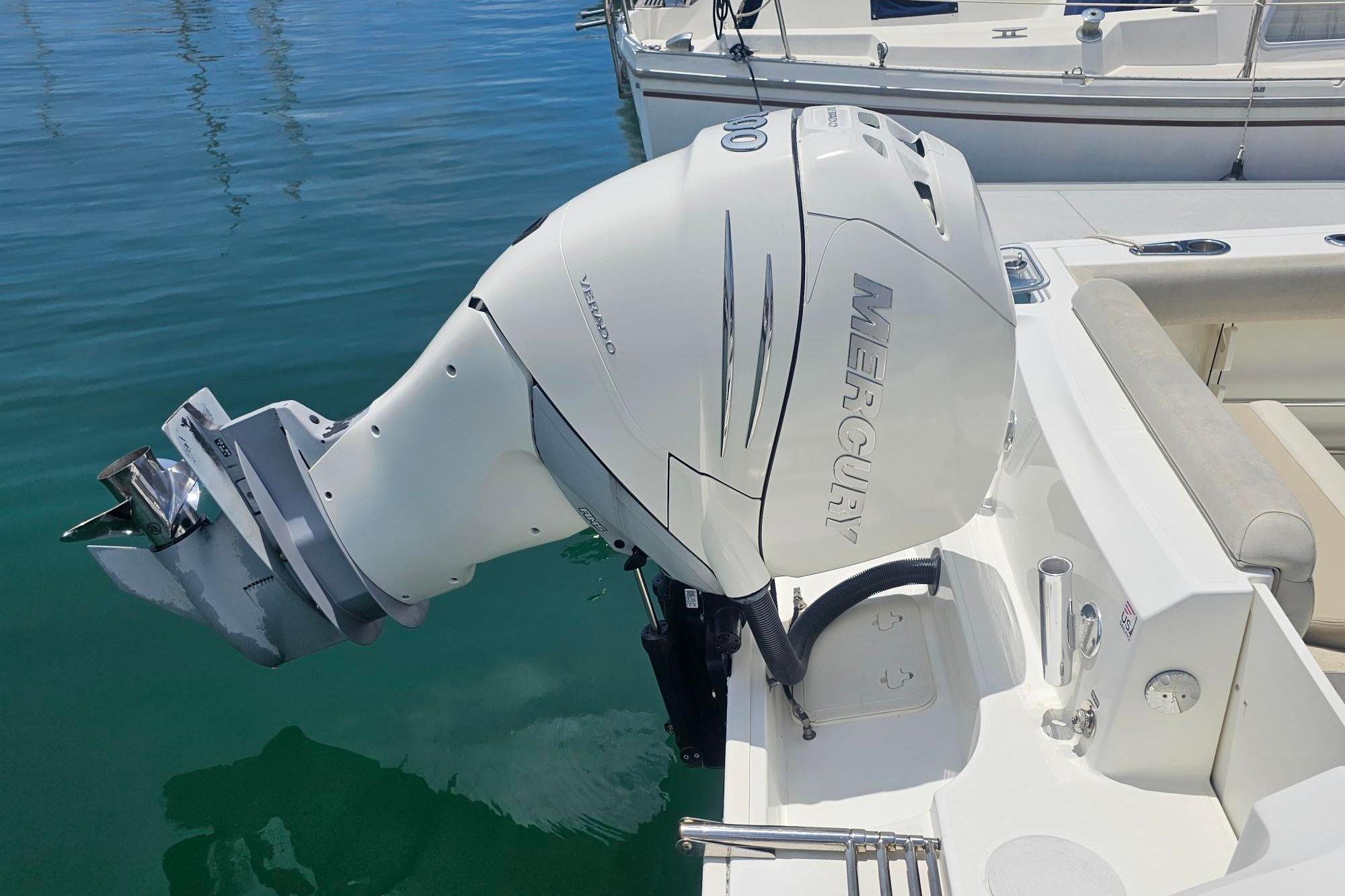 2017 Boston Whaler 230 Outrage with Mercury Verado outboard engine, docked on calm water.