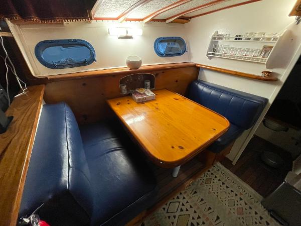 1951 Chris-Craft Catalina interior with wooden table, blue seating, and nautical decor.