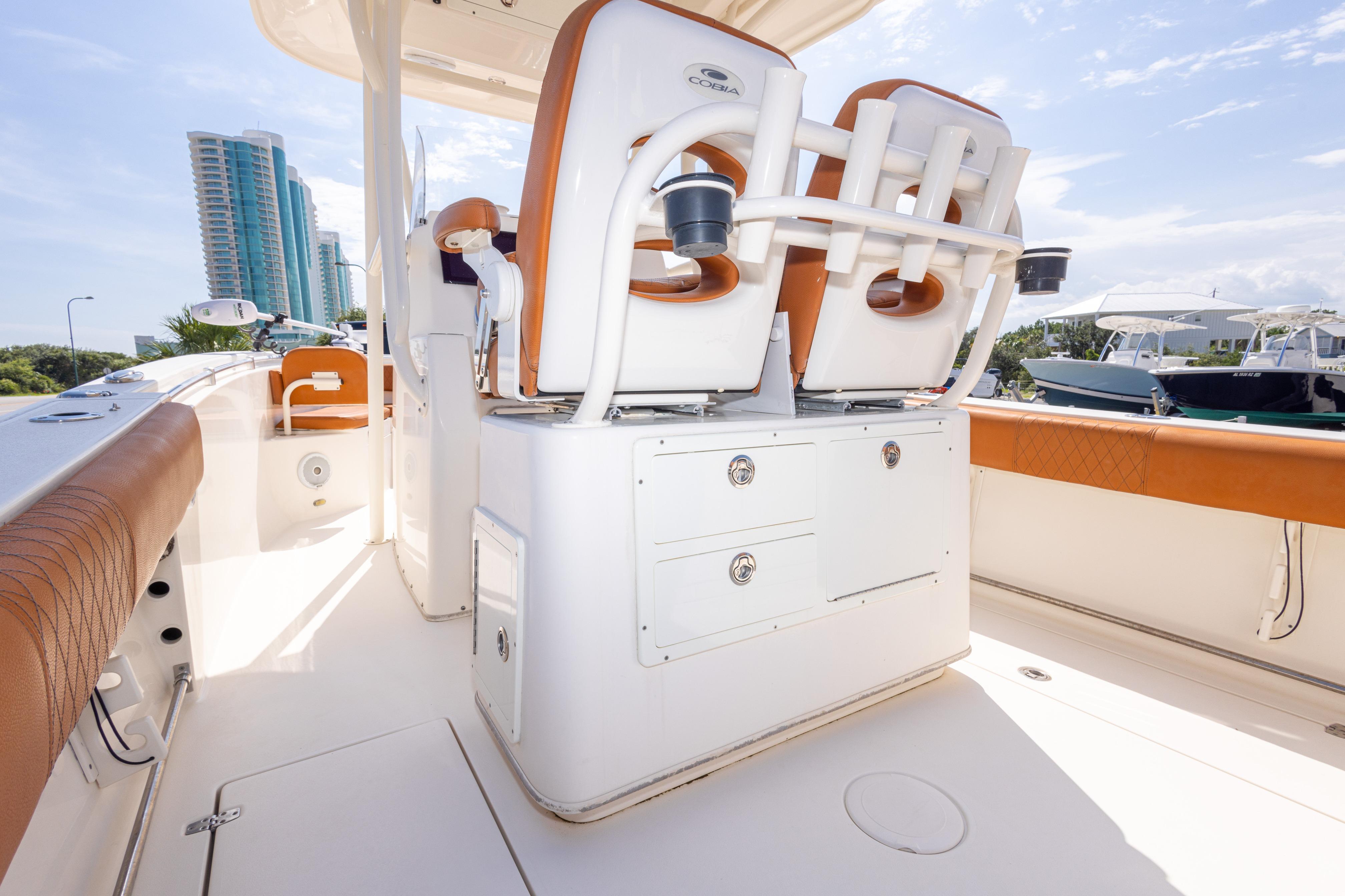 2017 Cobia 261 Center Console boat interior with seating and storage, docked near modern buildings.