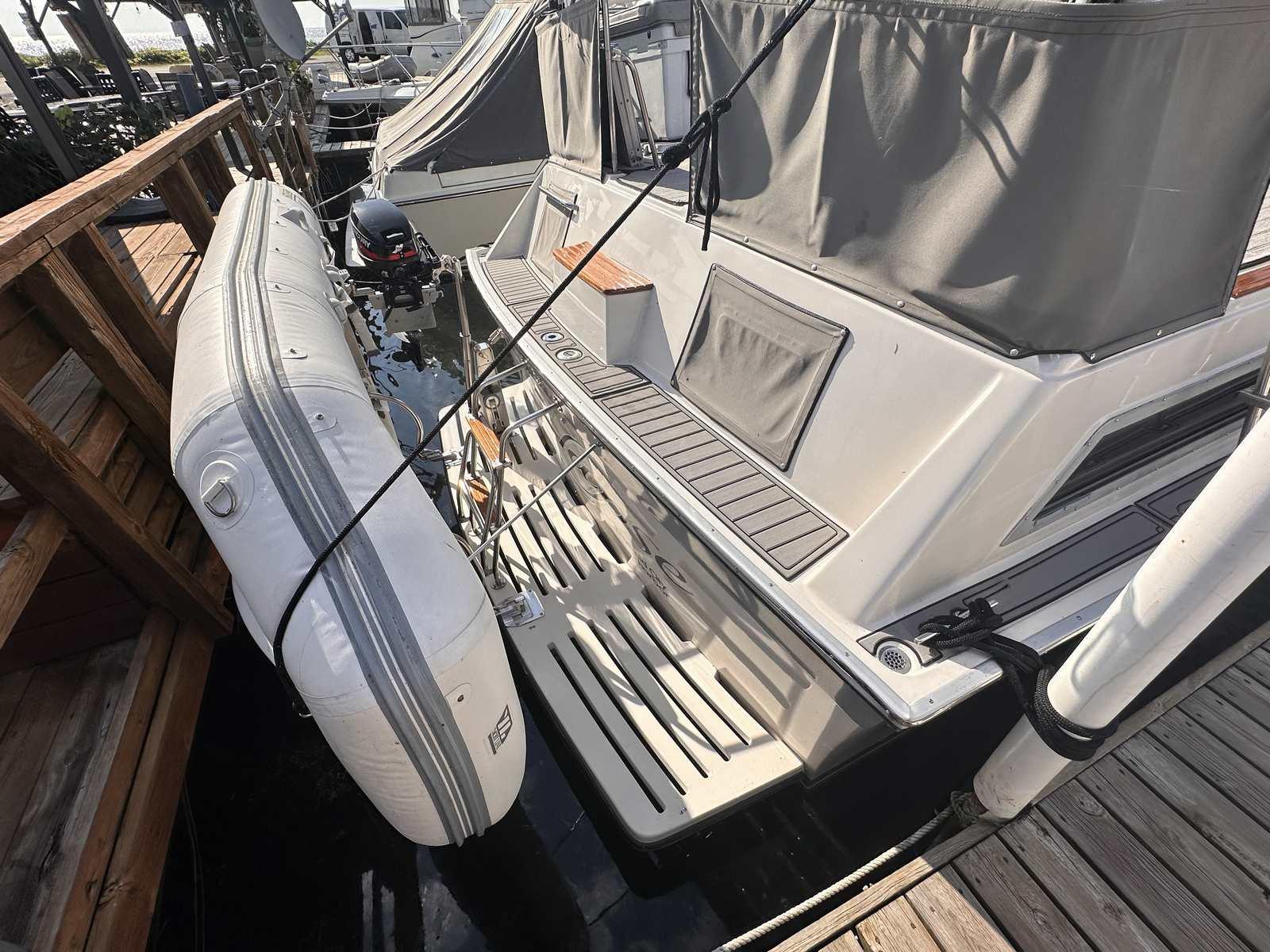 1987 Silverton 40 Double Cabin yacht with attached inflatable boat at dock.