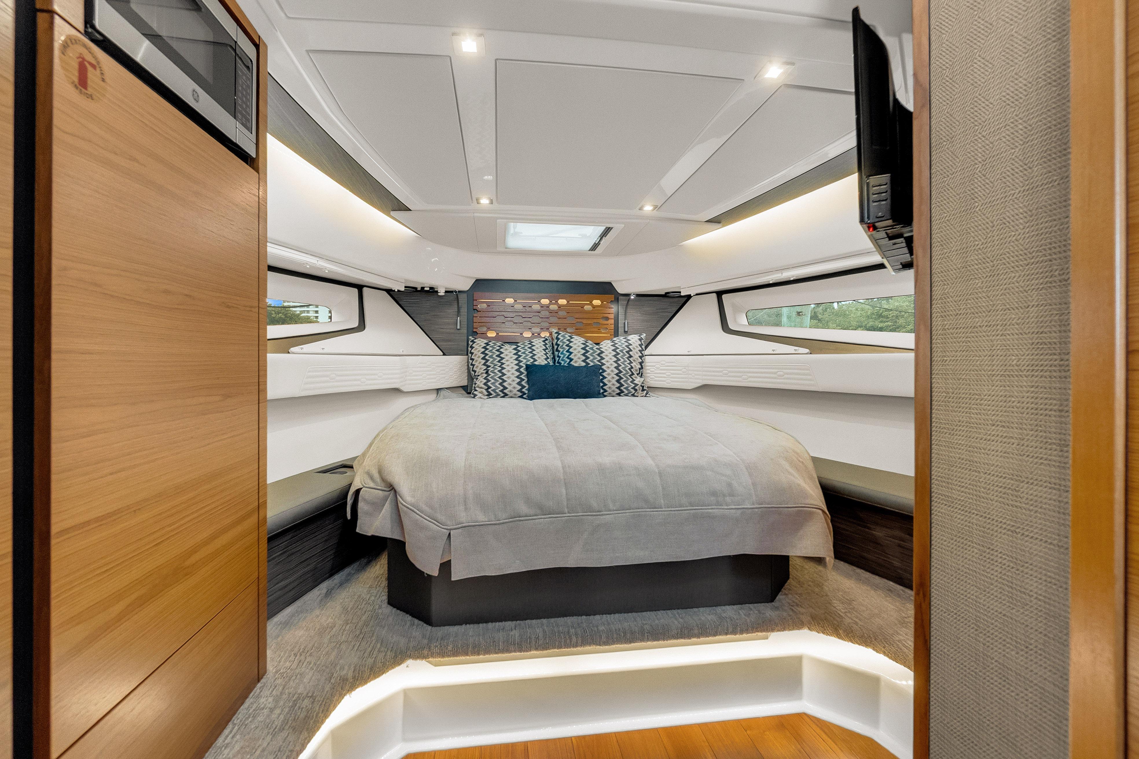 Luxurious 2021 Tiara Sport 43 LE yacht bedroom with modern design and ambient lighting.