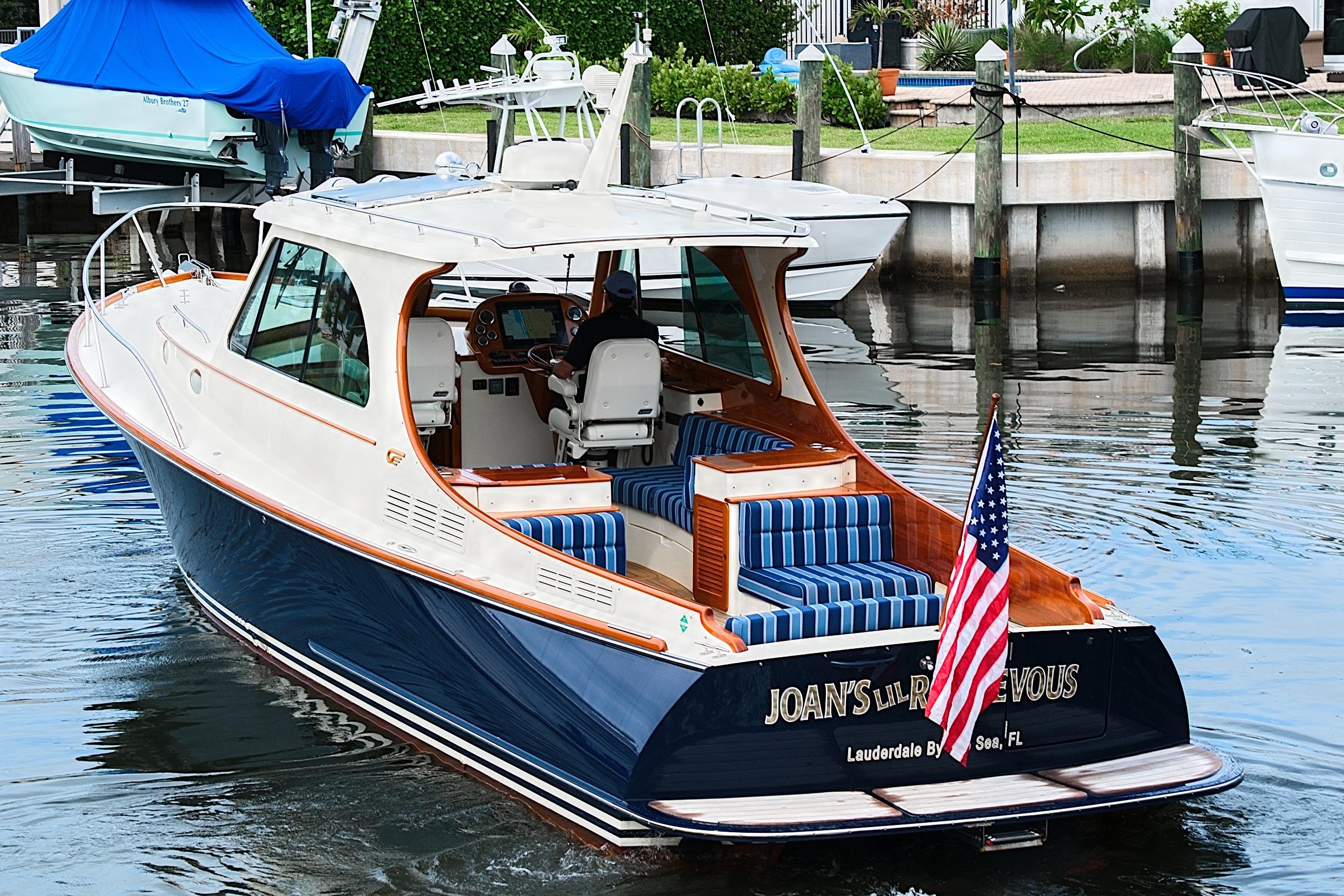 2018 Hinckley Picnic Boat 37 MKIII in marina, featuring elegant design and American flag.