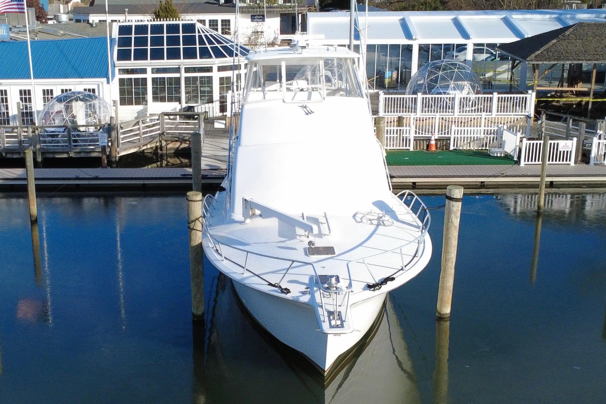 1999 Ocean Yachts 56 Super Sport docked at marina, front view.