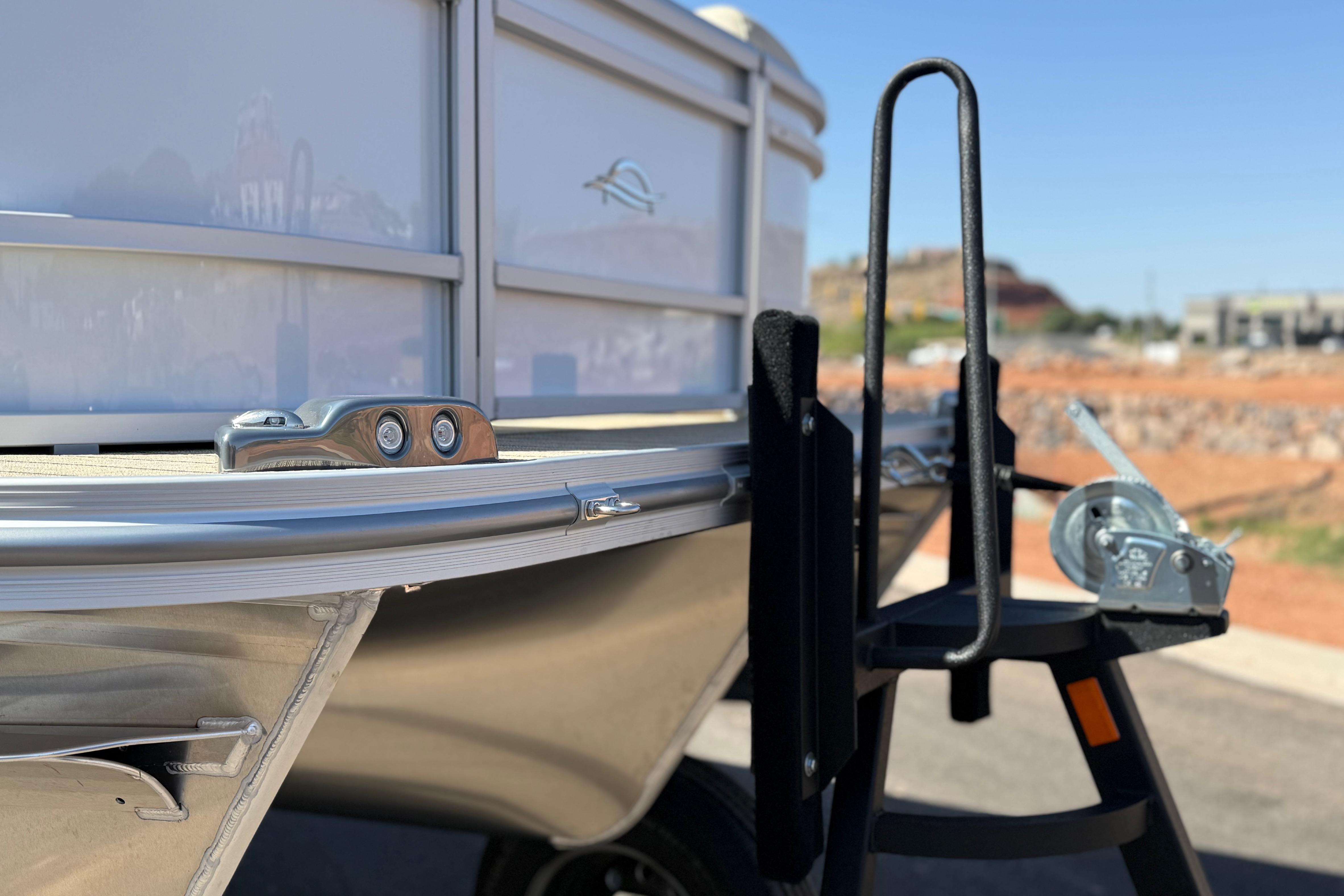 2026 SunCatcher Select 322SL boat detail with trailer winch in sunny outdoor setting.