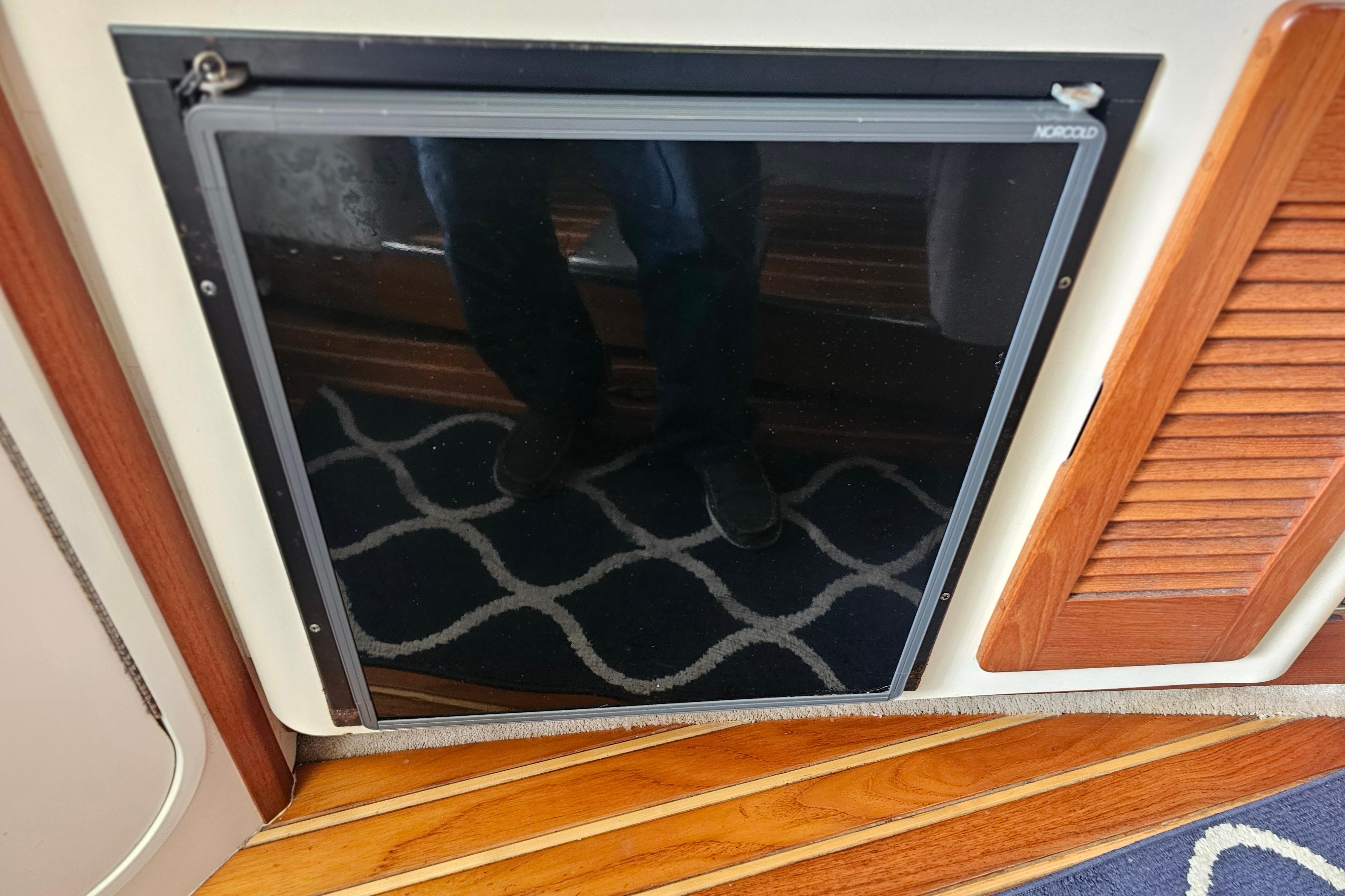 2001 Pursuit 3000 Express interior with Norcold fridge and wooden flooring.