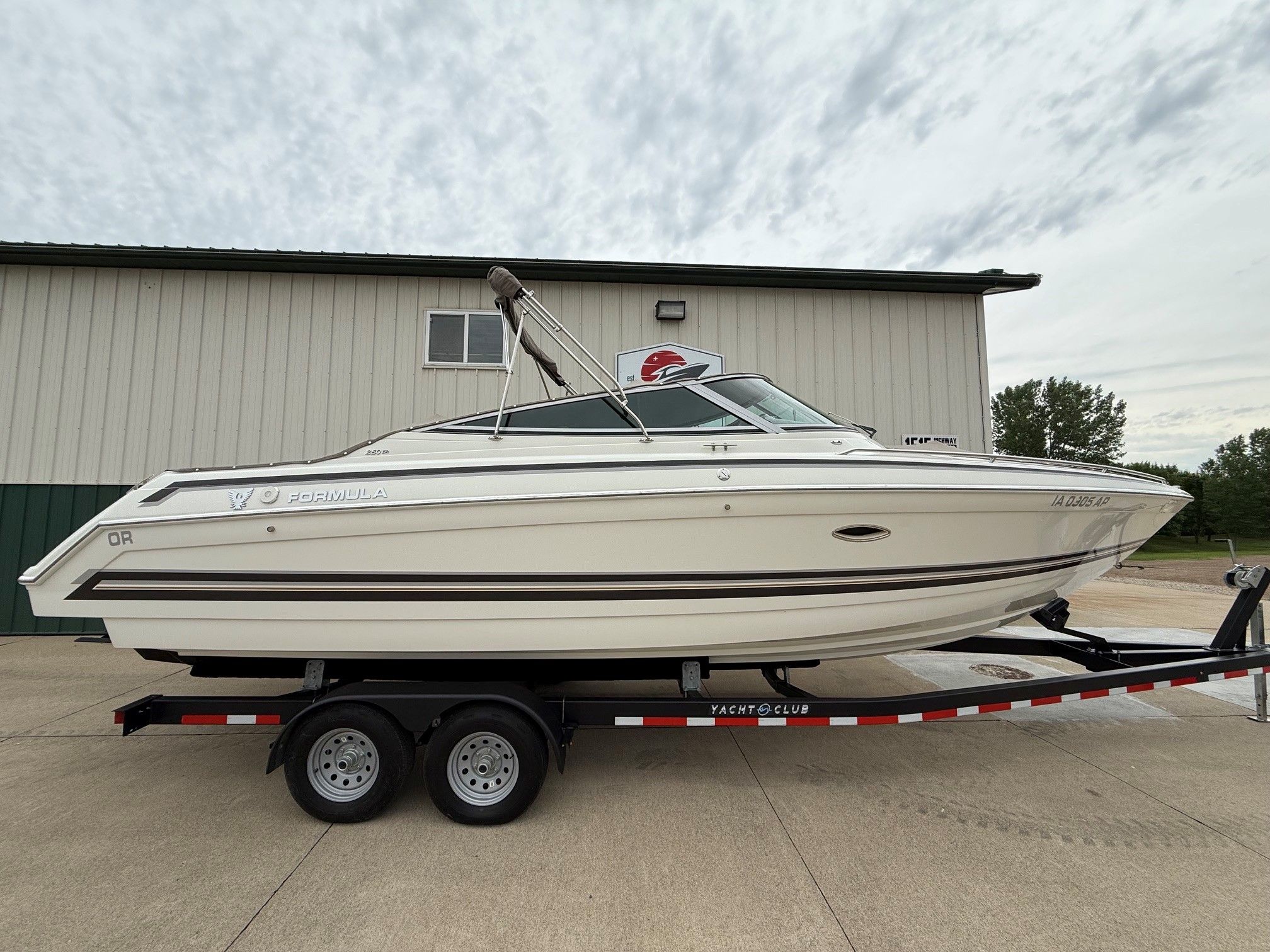 1998 Formula Thunderbird boat on trailer in front of building.