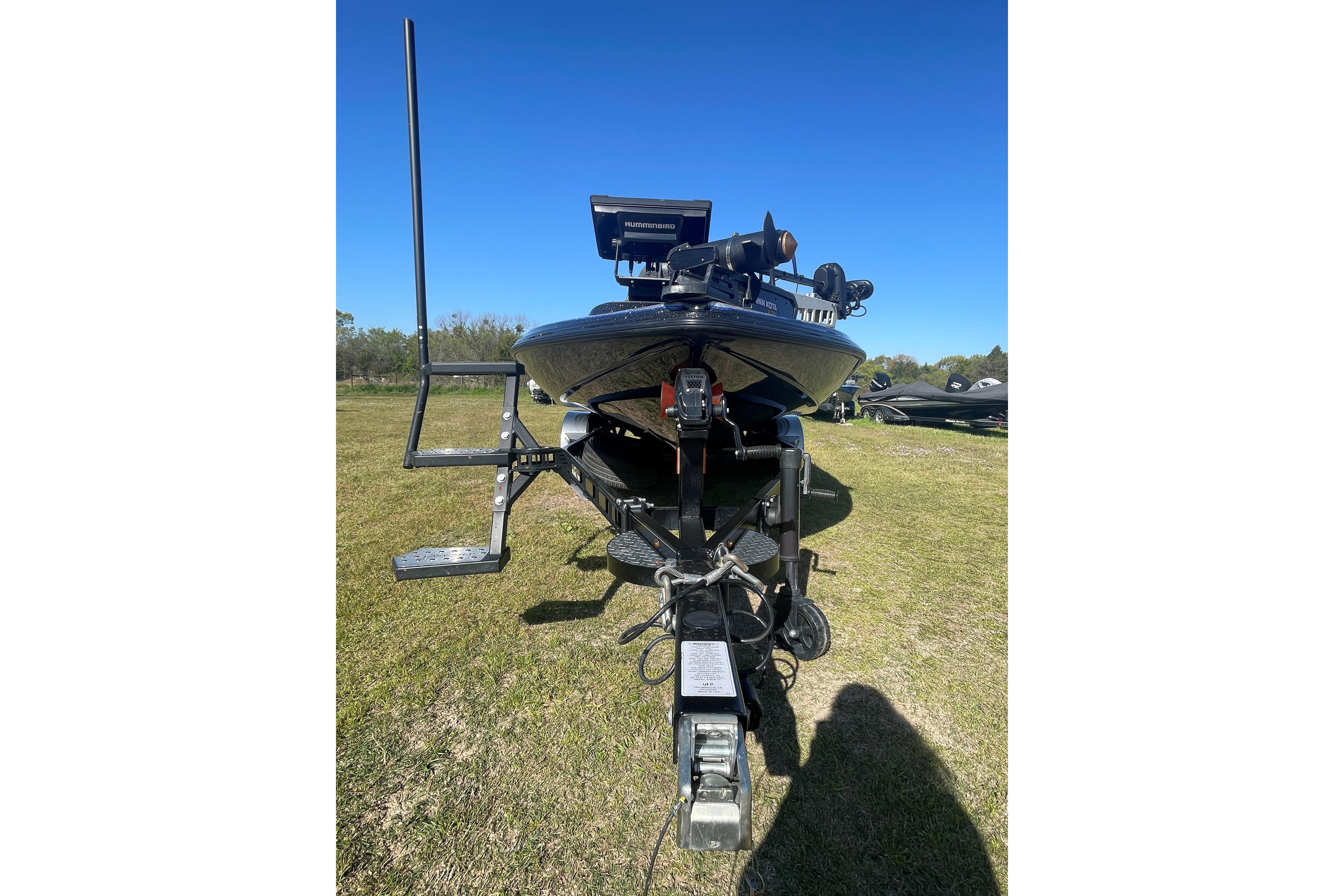 2021 Falcon Boats F20 PREDATOR on trailer, parked on grass under clear blue sky.