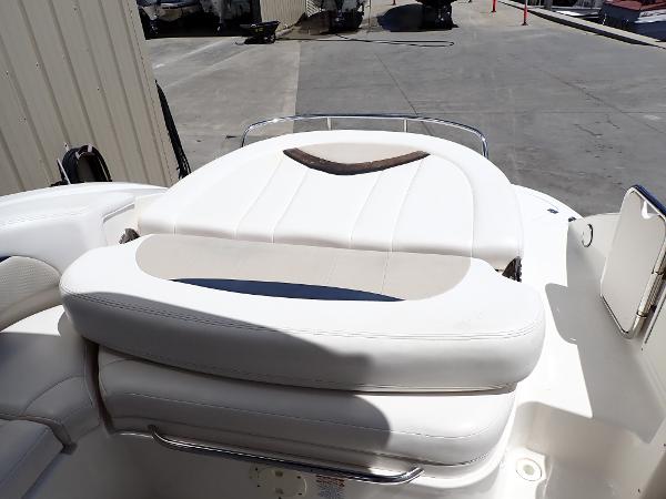 2011 Chaparral 287 SSX boat with white cushioned seating in a marina setting.