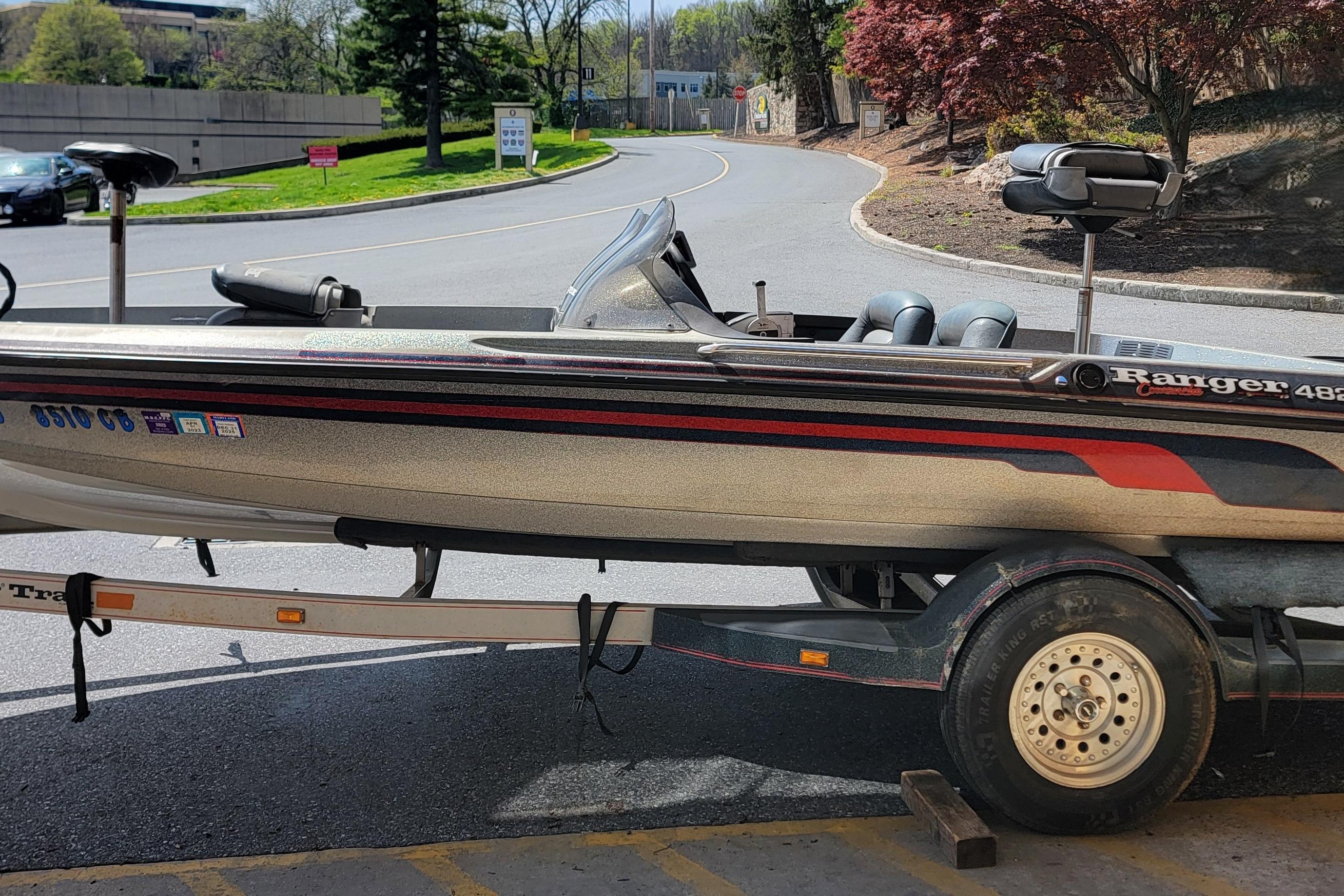 1995 Ranger boat on trailer, parked on a sunny road with trees in the background.