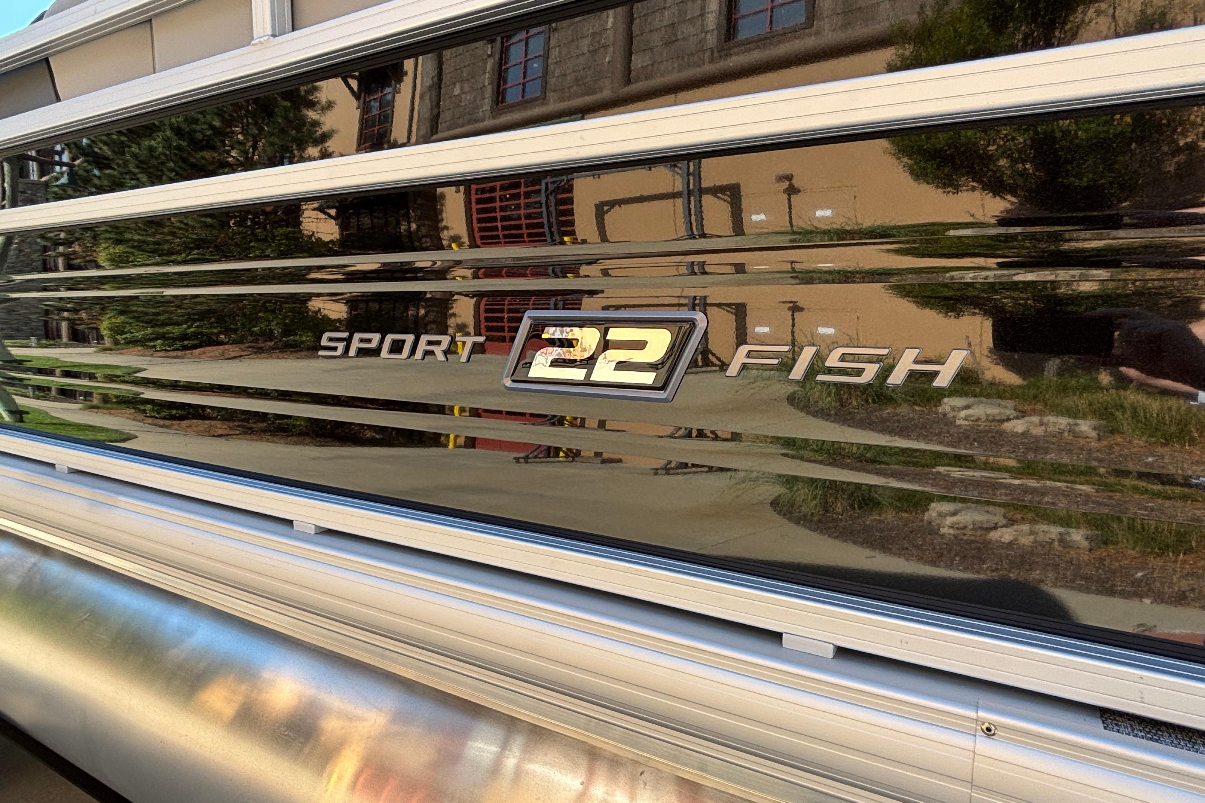2026 Sun Tracker SportFish 22 DLX boat exterior with reflective surface.