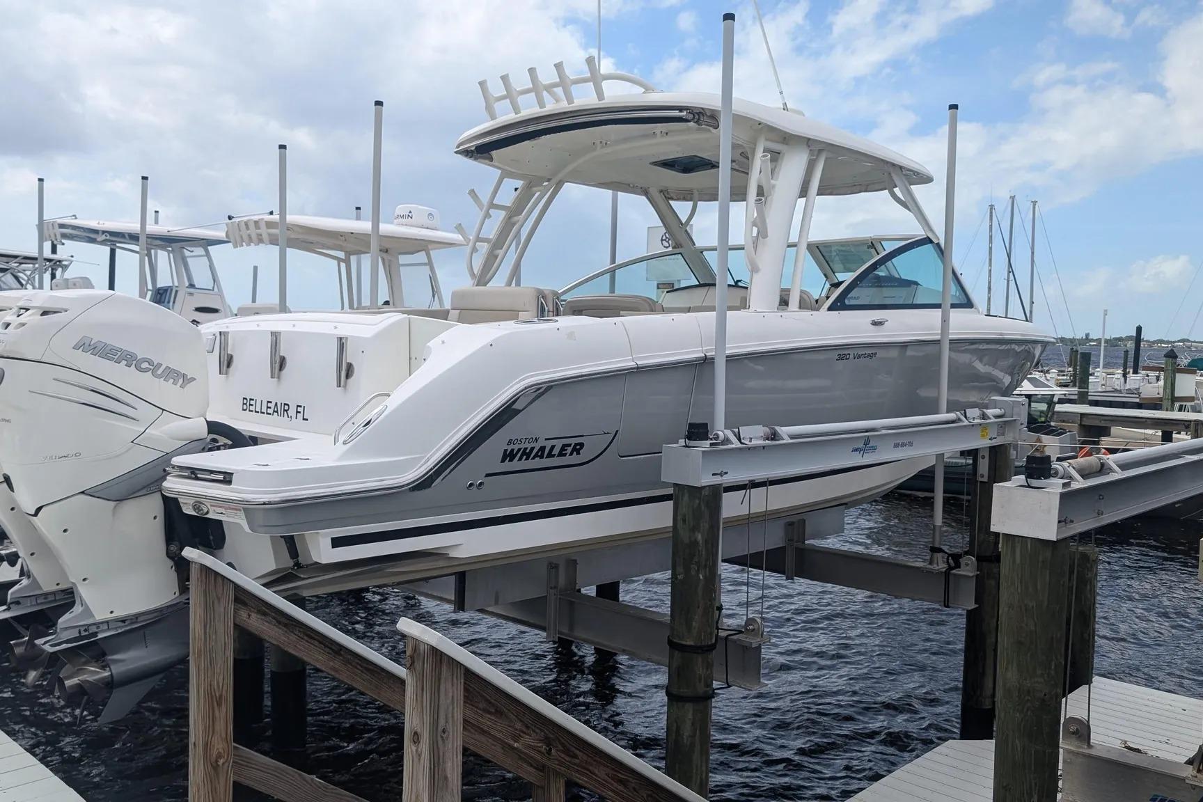 2017 Boston Whaler 320 Vantage boat on lift at marina, side view.
