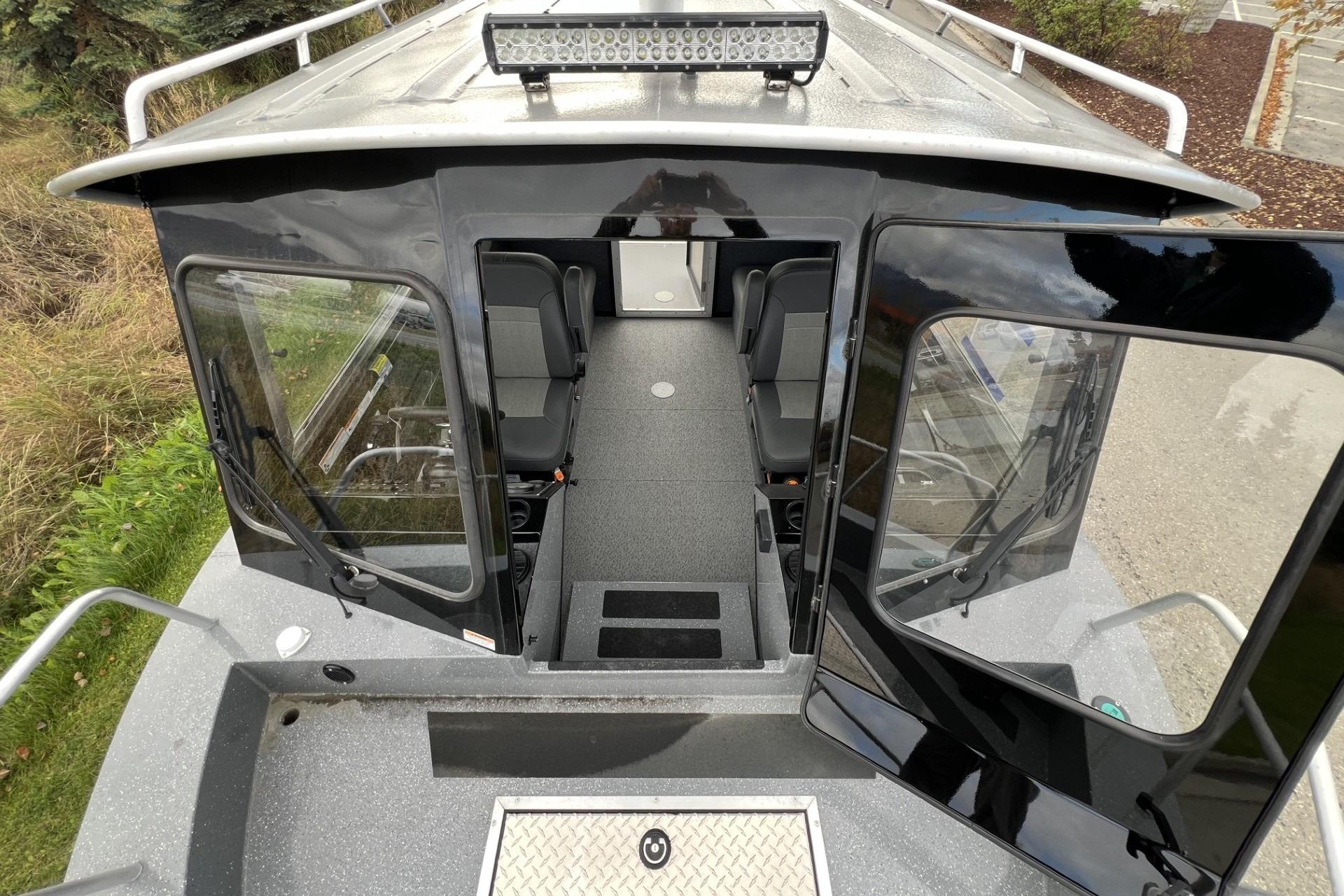 2024 Spartan 220 Maximus boat interior with seating and open doors, showcasing modern design.