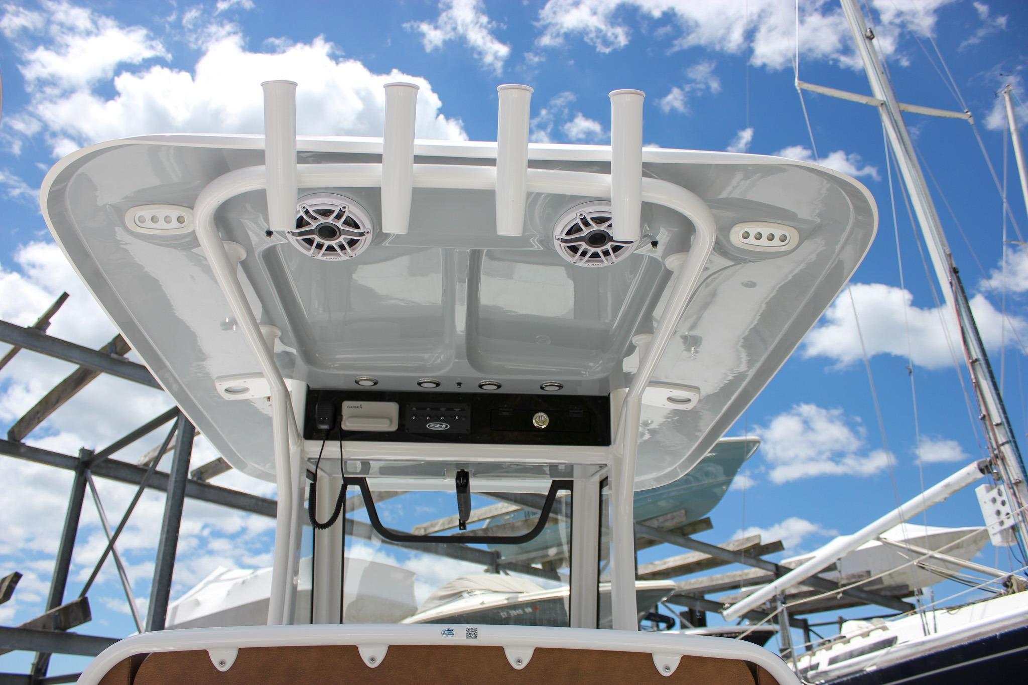 T-top of 2027 Sea Hunt Ultra 275 SE boat with rod holders and speakers under blue sky.
