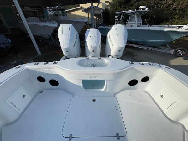 2025 Yellowfin 39 Offshore boat with triple outboard engines, docked at a marina.