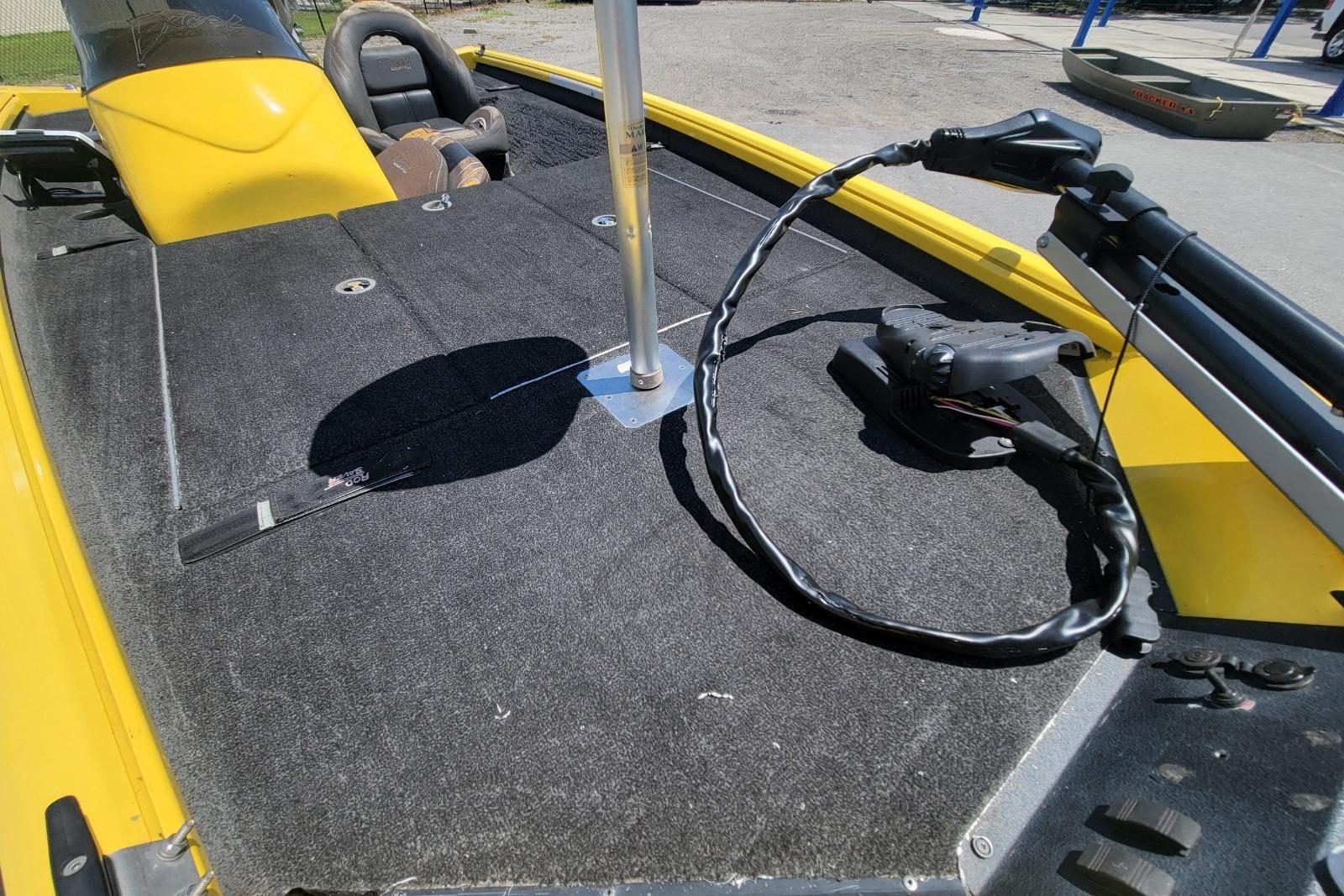 Yellow 2011 Excel 1751 F4 boat interior with carpeted deck and steering console.