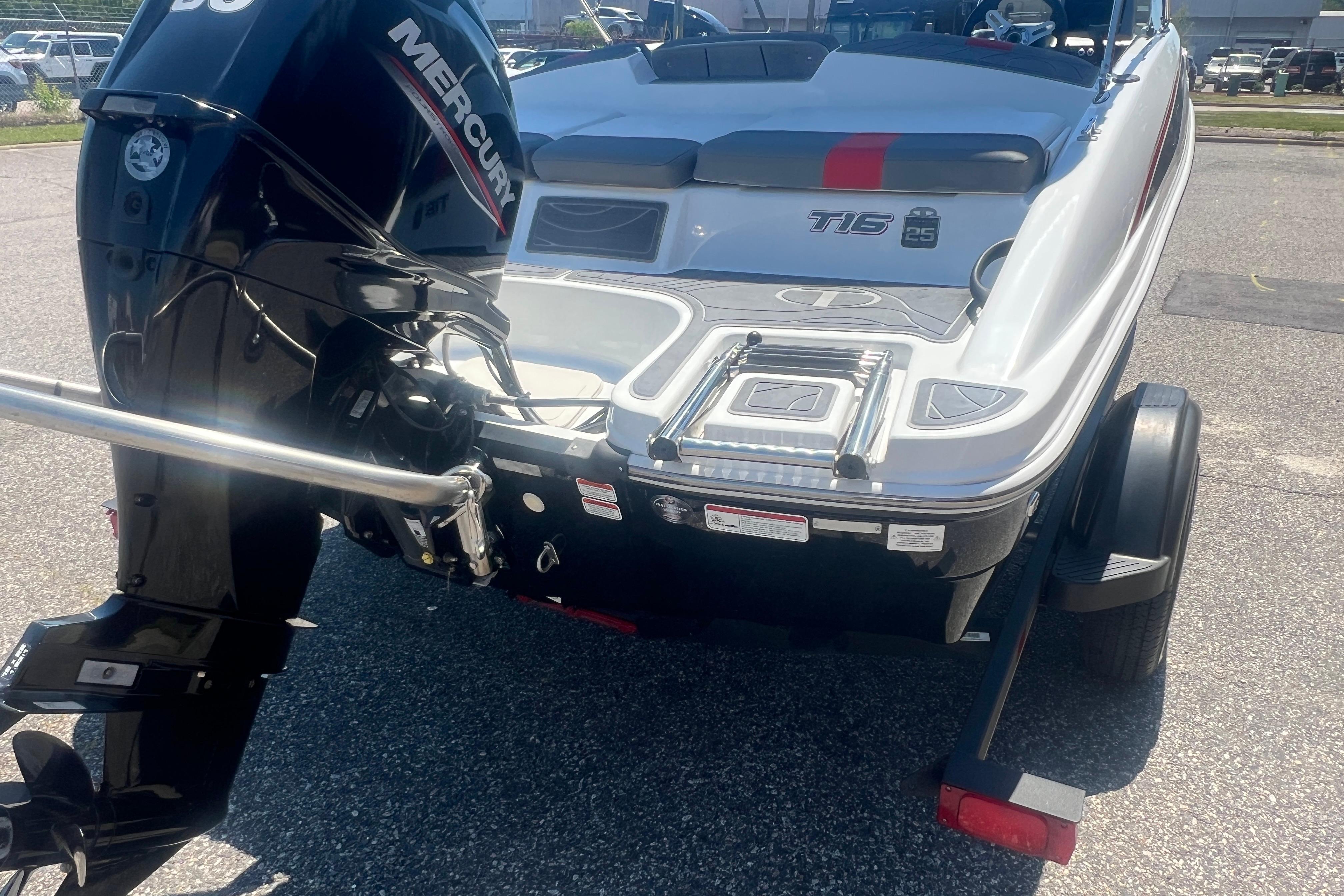 2023 Tahoe T16 boat with Mercury engine, rear view on trailer in parking lot.