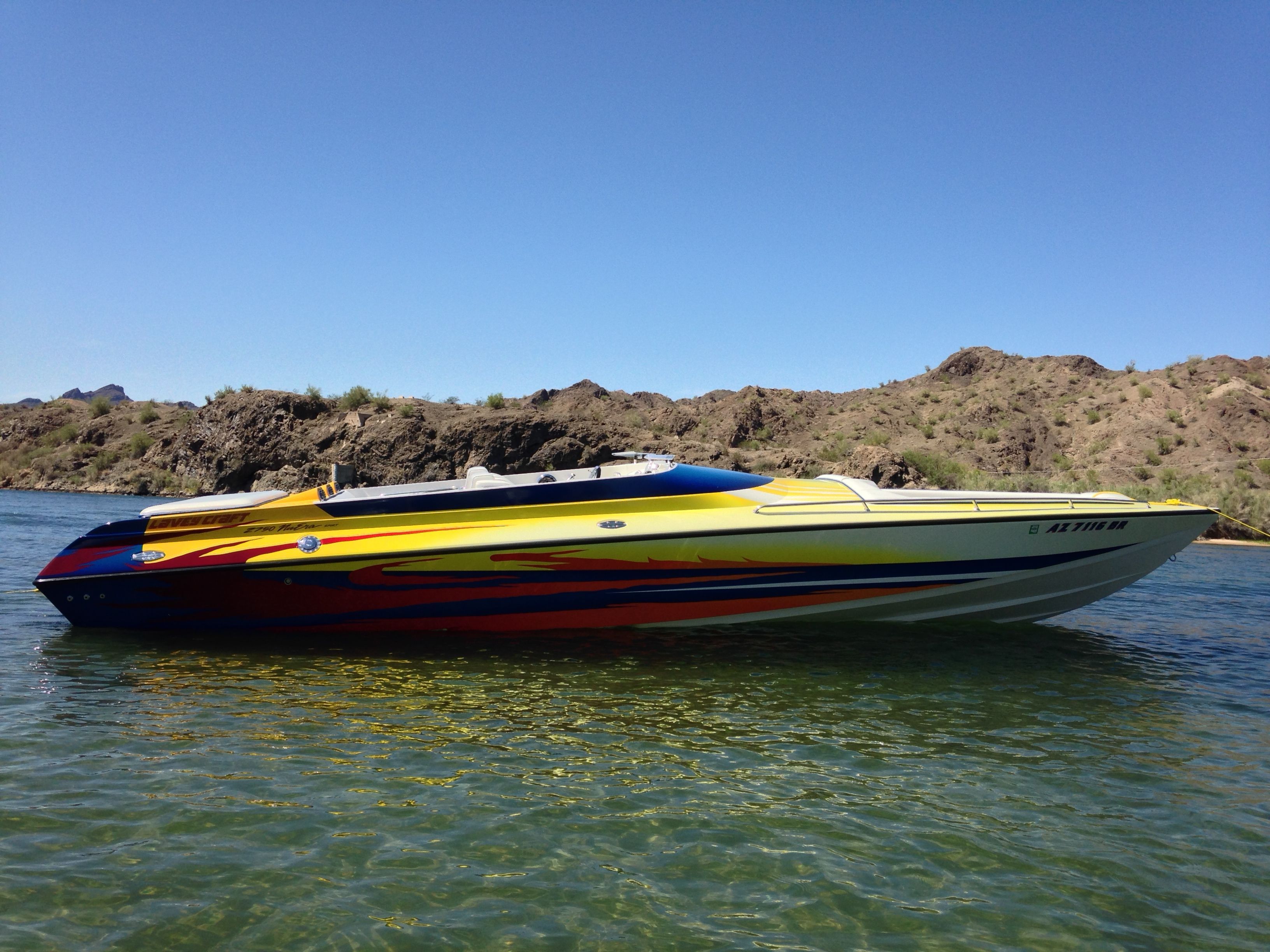 2002 Lavey Craft 2750 NUERA boat on water near rocky shore.