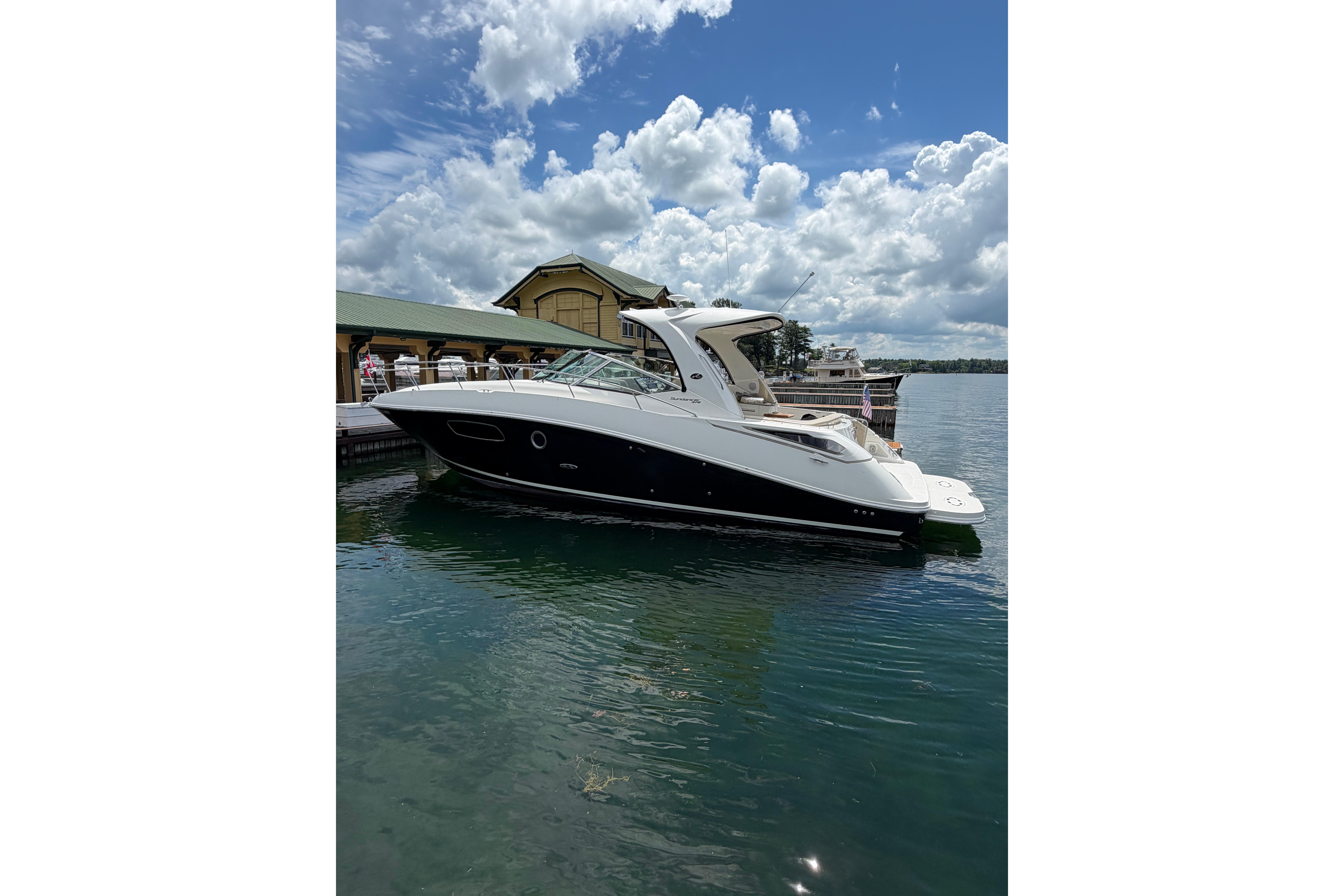 2012 Sea Ray Sundancer 370 yacht docked on a sunny day with cloudy sky.
