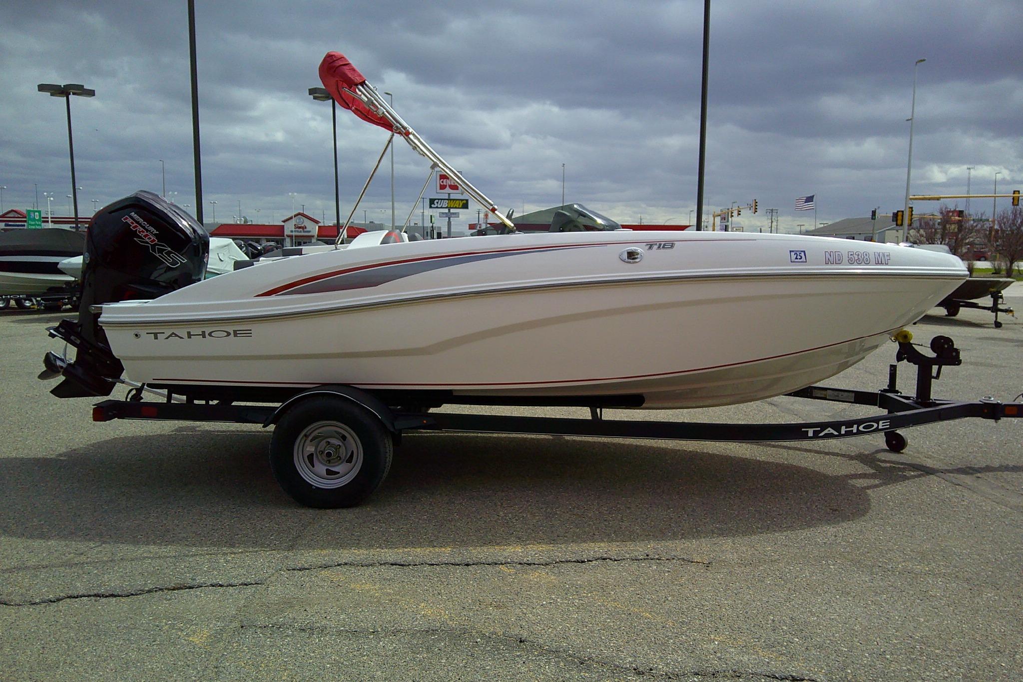 2024 Tahoe T18 boat on trailer in parking lot, overcast sky background.