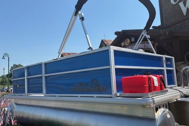 2026 Sun Tracker Party Barge 16 DLX pontoon boat with blue panels and red fuel container.