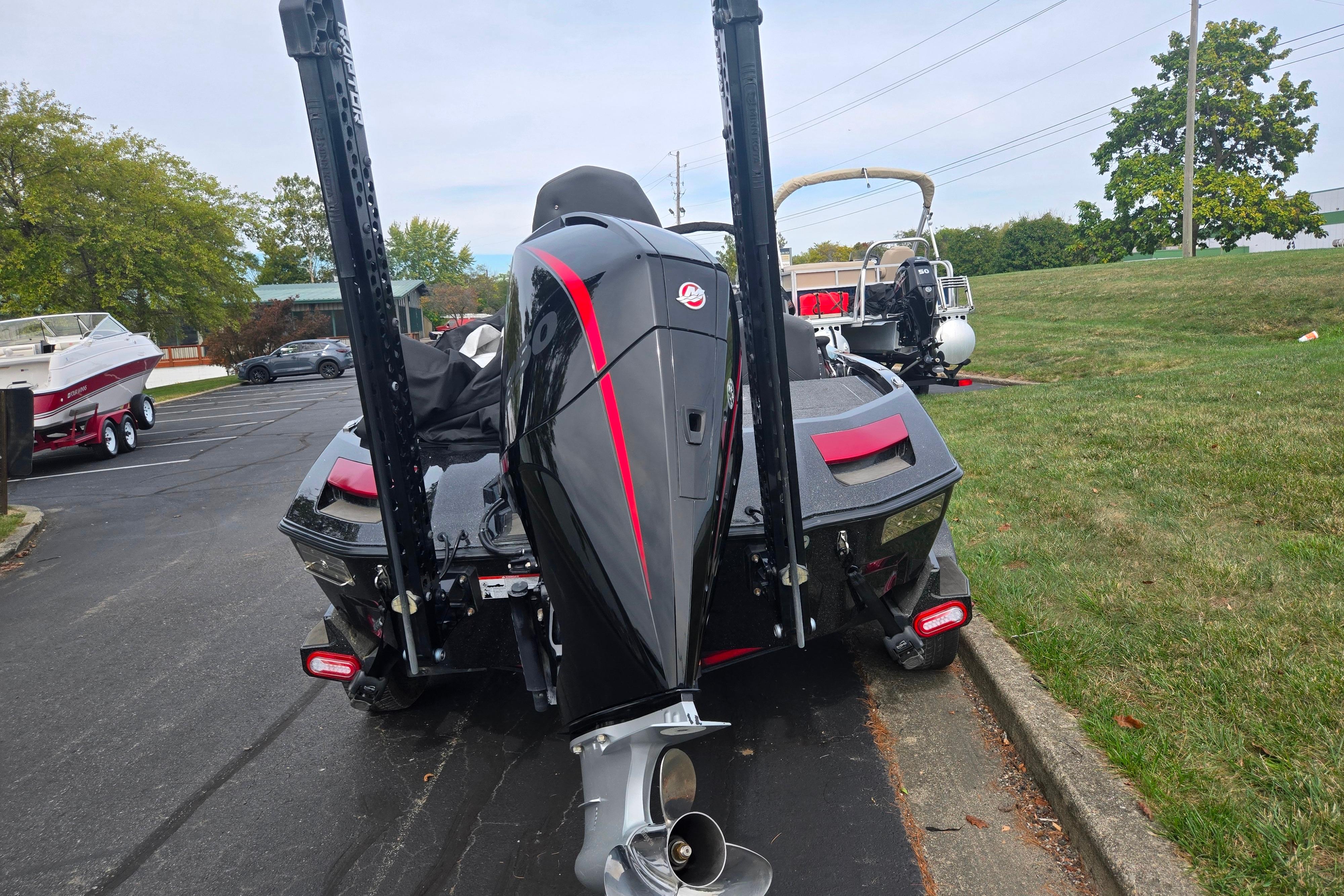 2022 Vexus VX20 boat with powerful outboard motor, parked on pavement near grass.