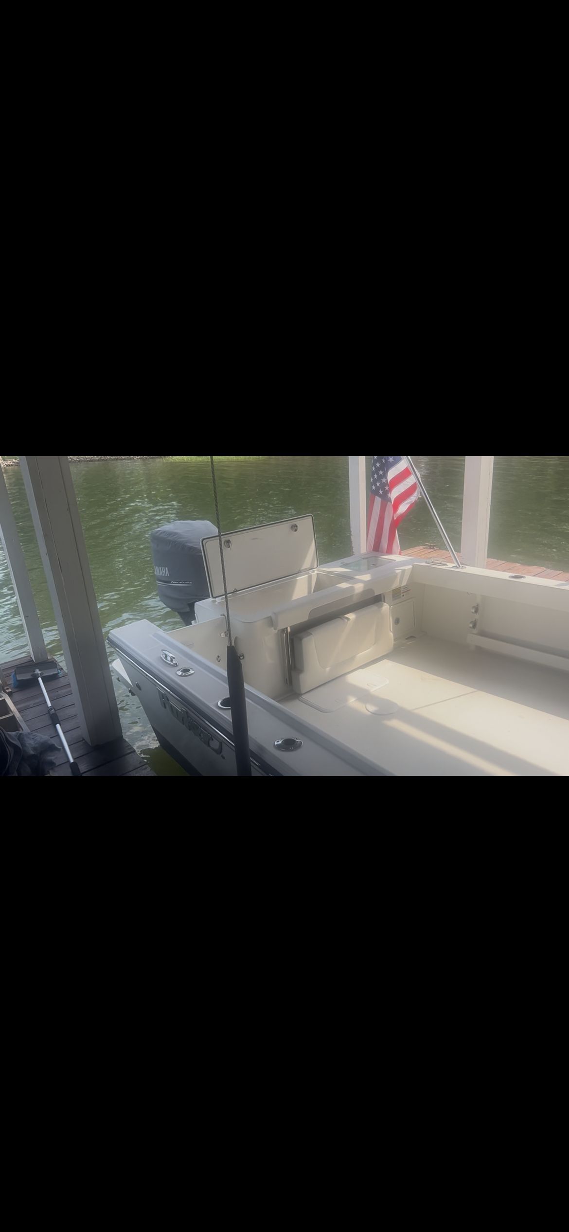A Parker 2320 Sport Cabin boat docked with an American flag displayed.