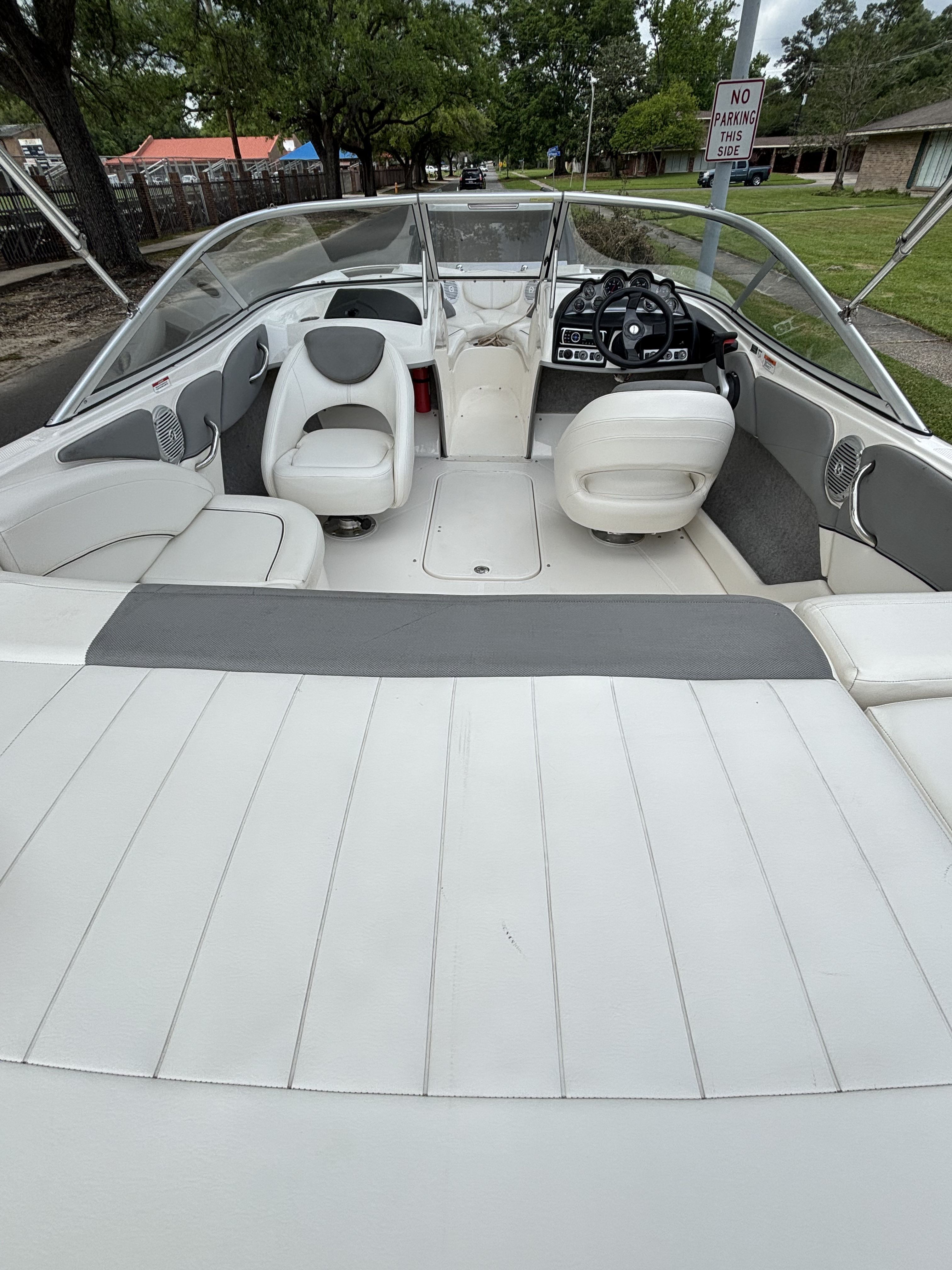 Interior view of a Bayliner 215 Bowrider with white seats and steering wheel.