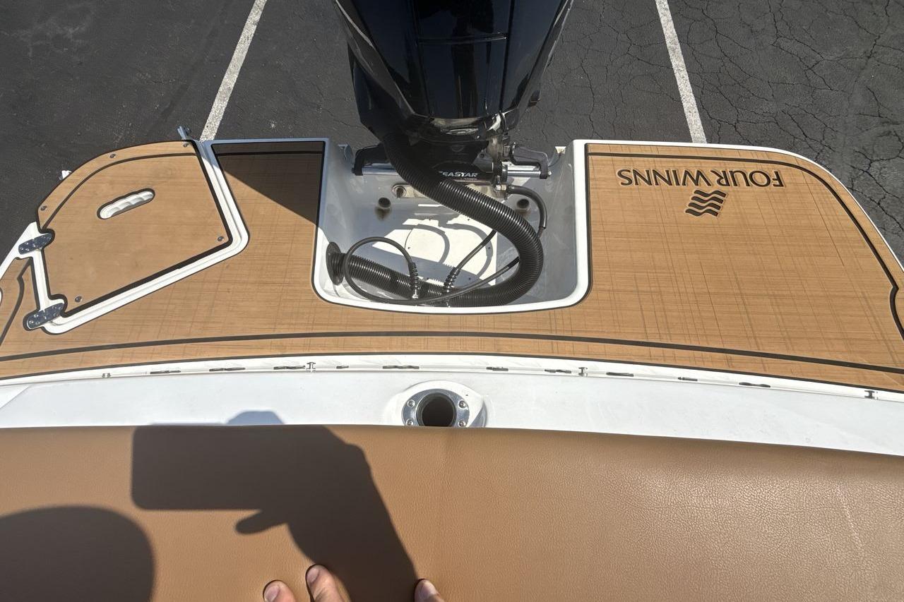2024 Four Winns H1 OB boat deck with tan finish and engine compartment.