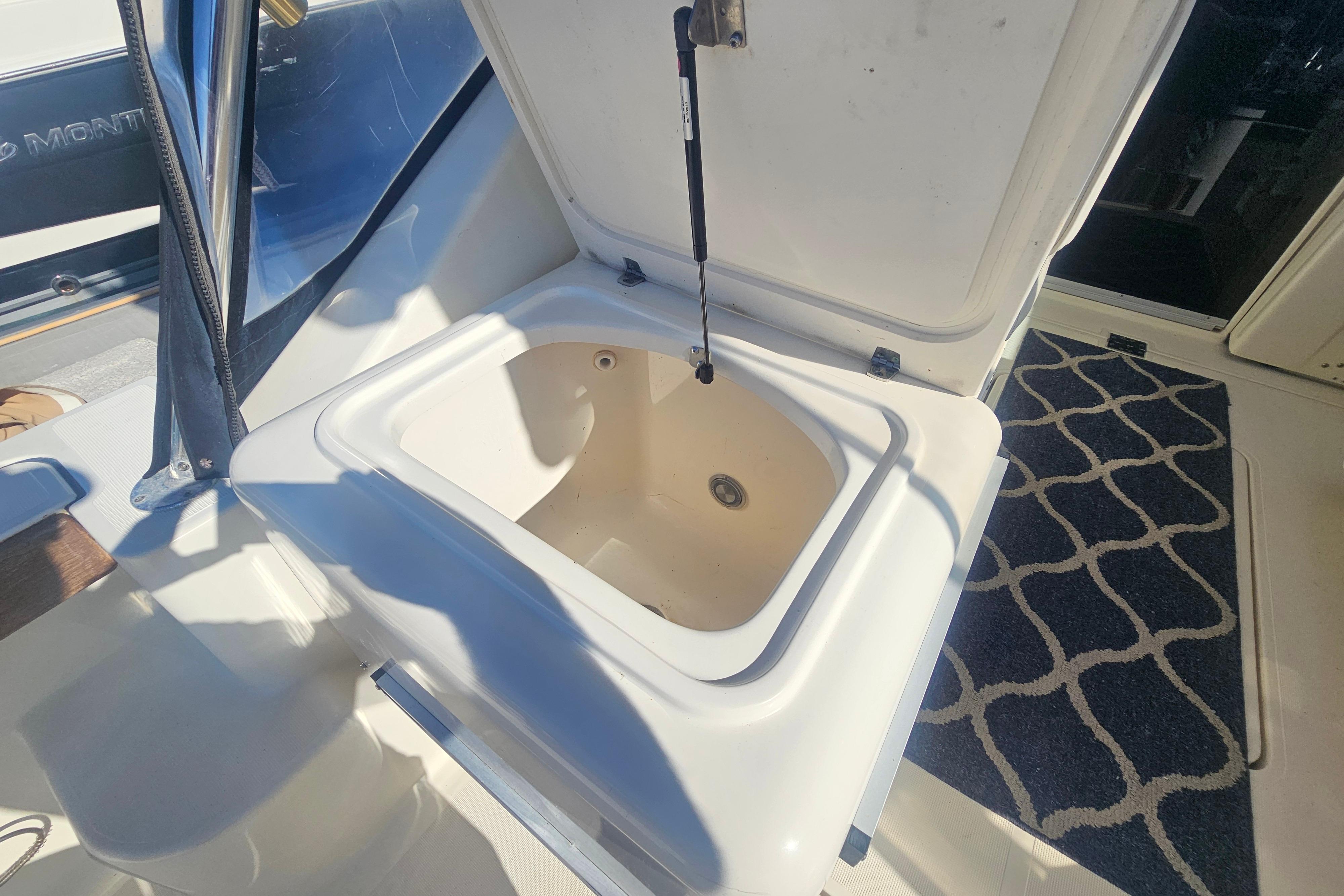 Open storage compartment on 2001 Pursuit 3000 Express boat, featuring a hydraulic lift.