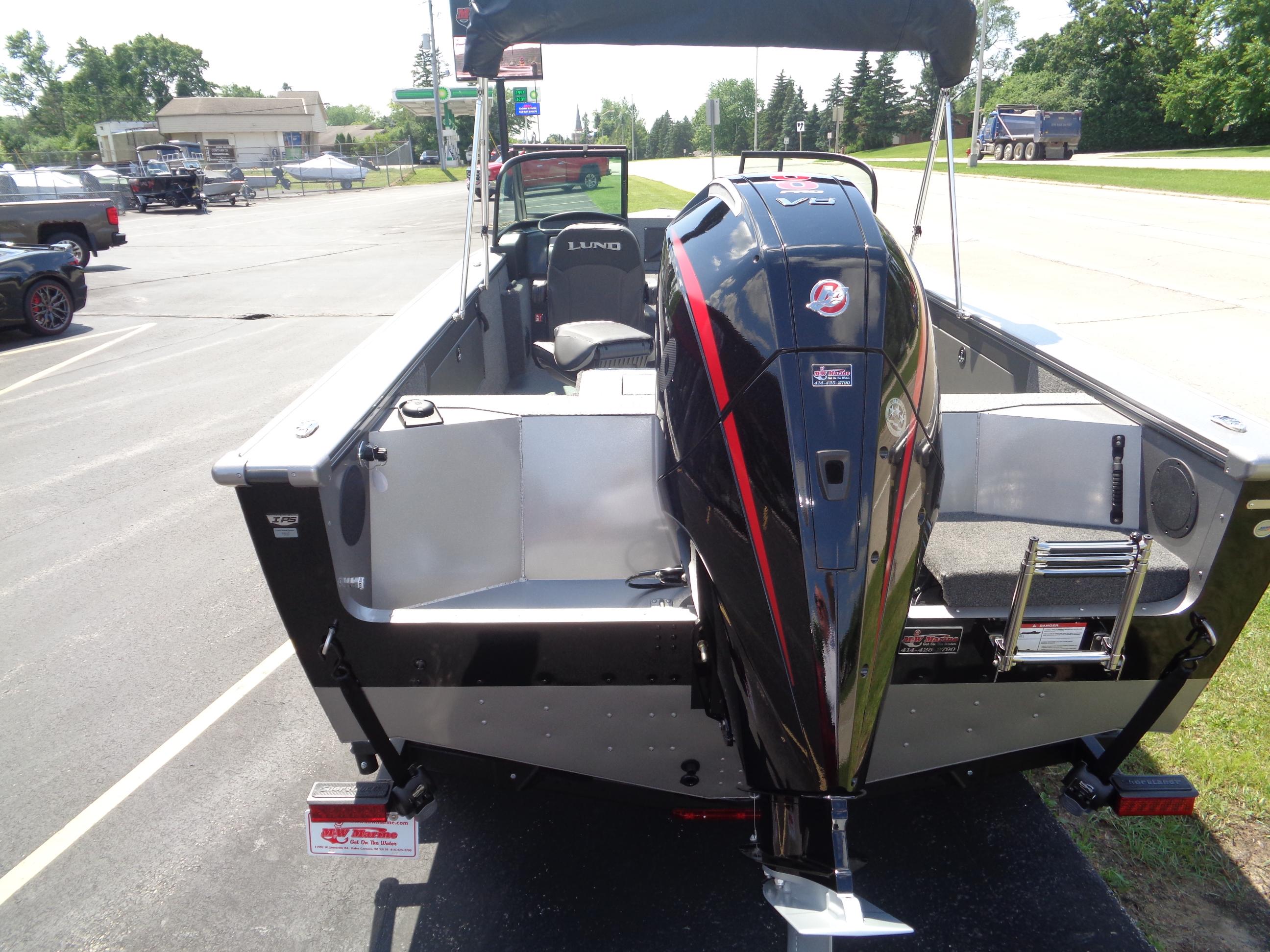 2025 Lund 2075 Fisherman boat with powerful outboard motor, parked on a sunny day.