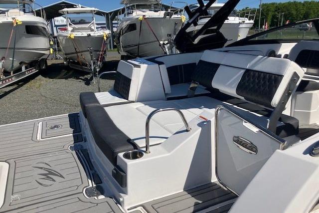 2024 Monterey M-65 boat interior with sleek seating and modern design, docked near other boats.