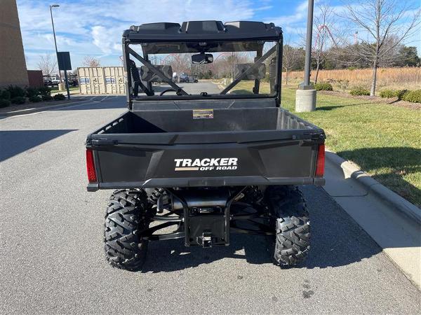 2024 Tracker Off Road 800SX LE Camo utility vehicle, rear view, parked outdoors.