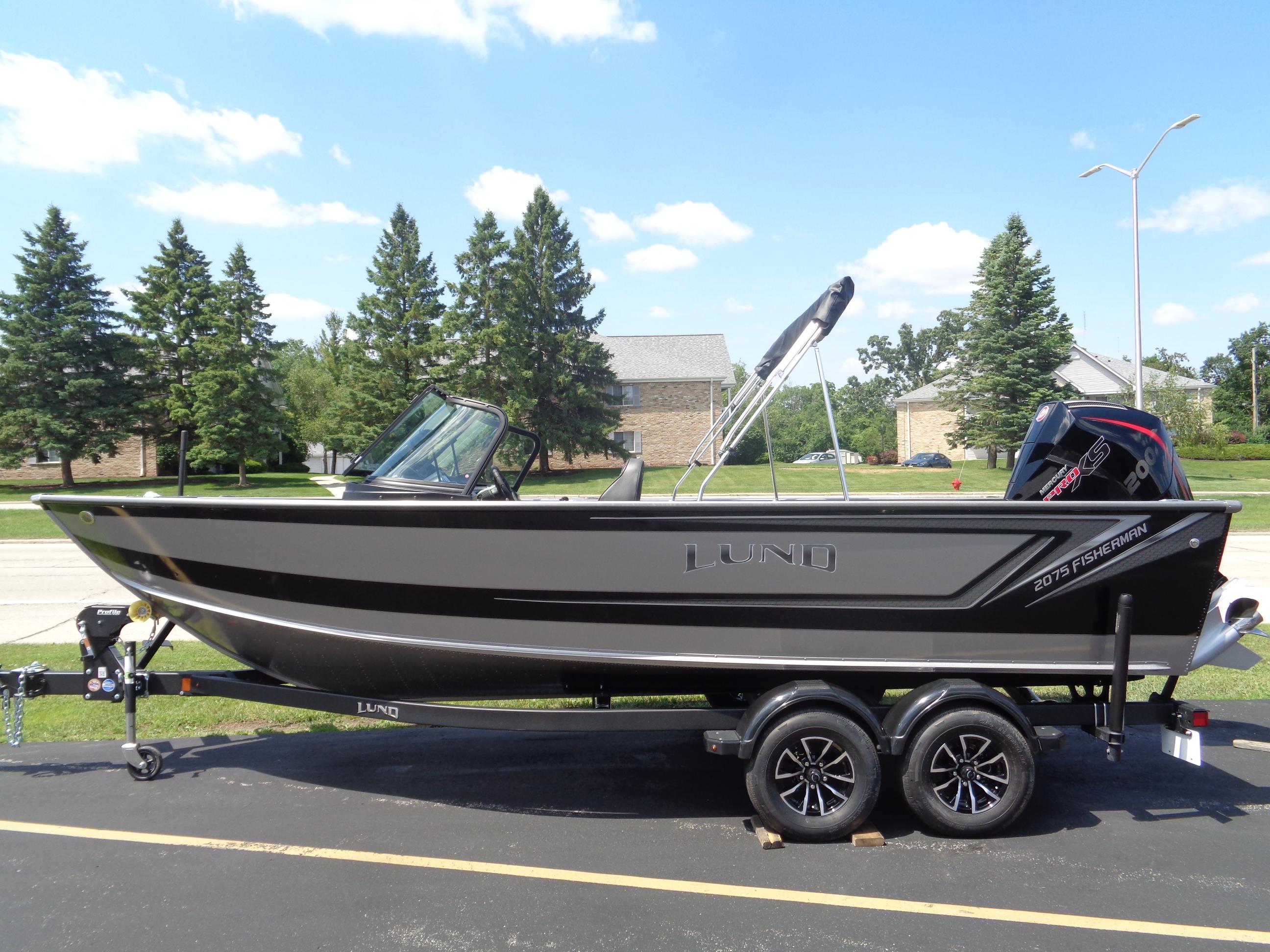 2025 Lund 2075 Fisherman boat on trailer, parked outdoors, sunny day.