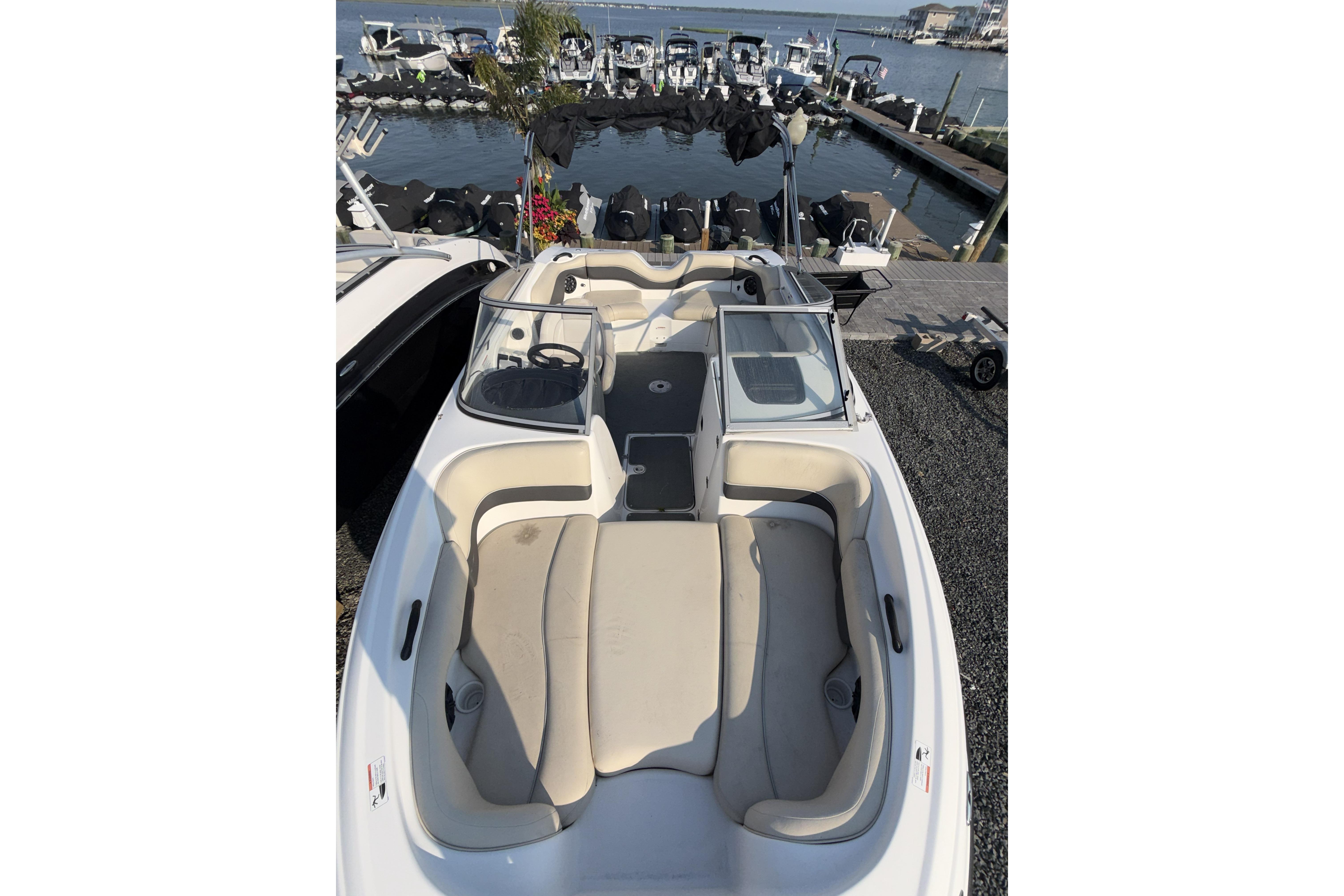 2006 Yamaha Boats SX210 with beige seating, docked near a marina.