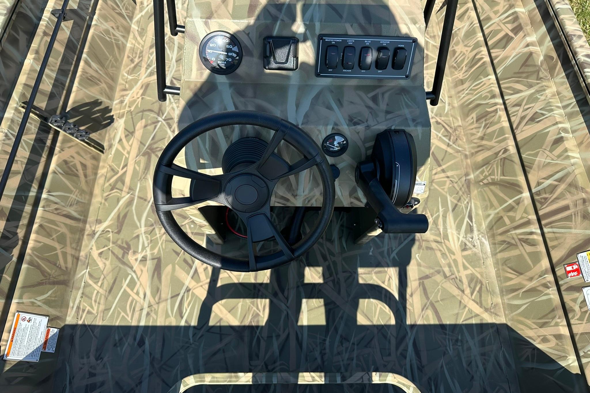 2026 Lowe Roughneck 2070CC boat console with camouflage design and steering wheel.