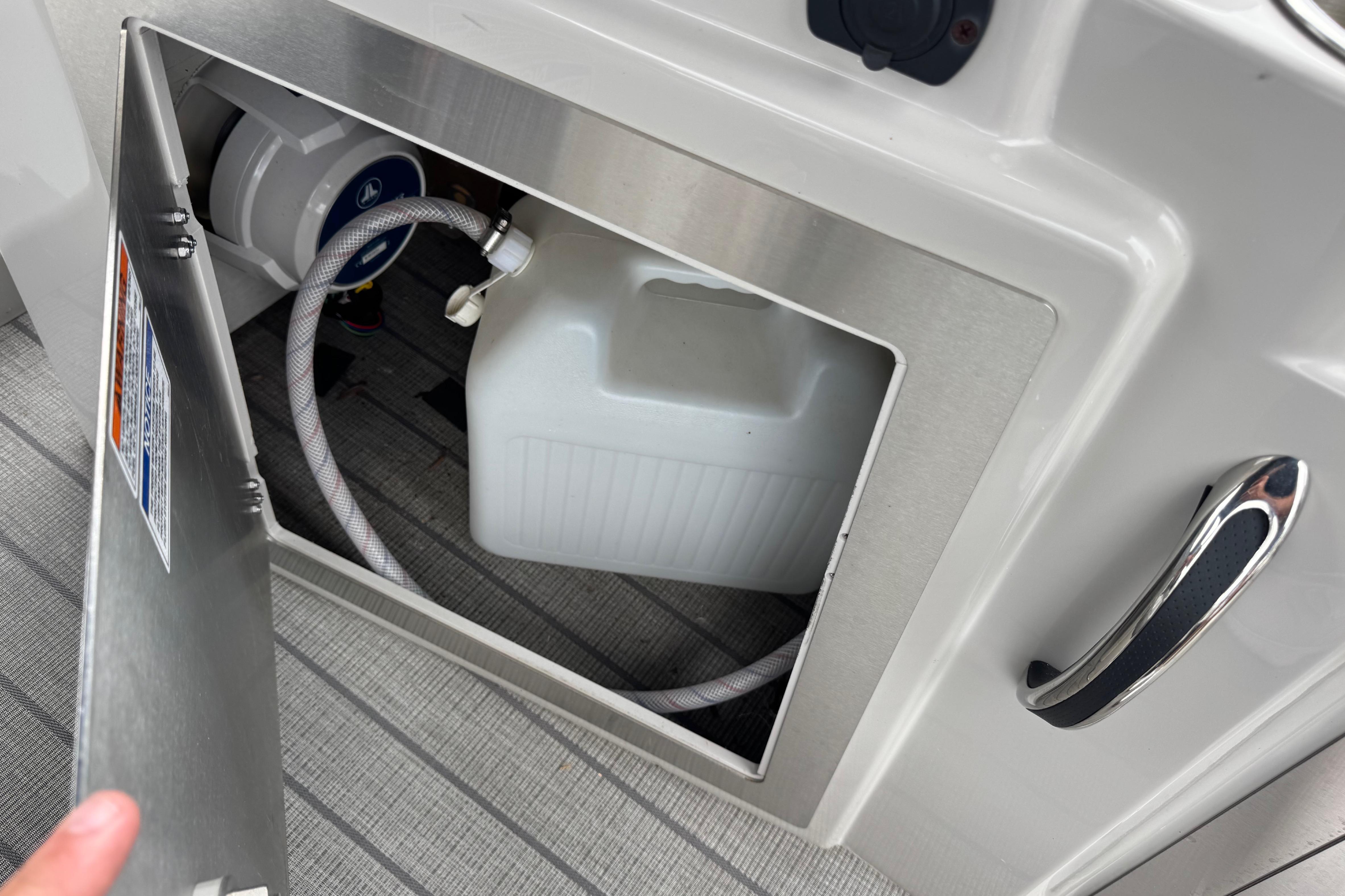 2023 Starcraft MX 25 DL DH boat compartment with water tank and hose.