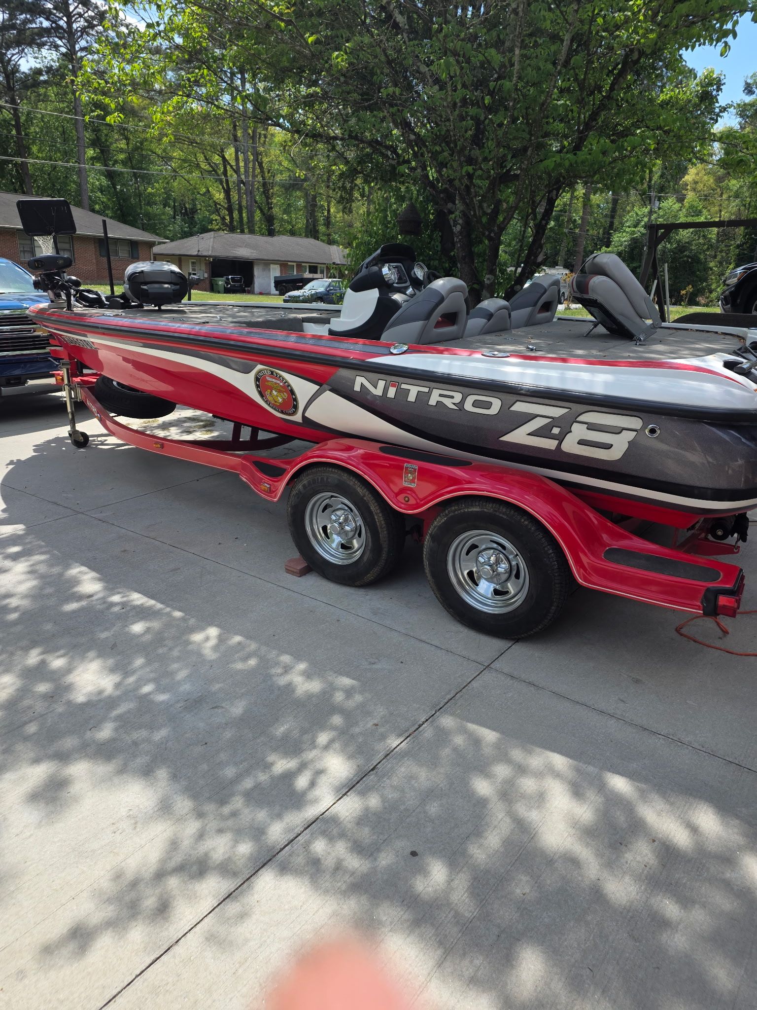 A red 2010 Nitro Z-8 boat on a trailer in a driveway.