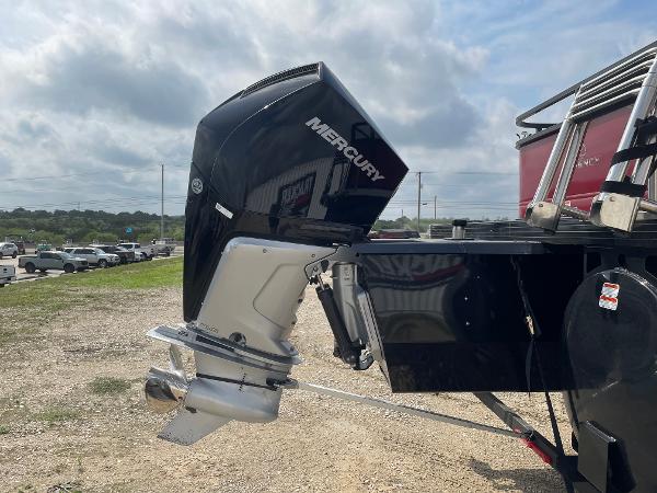 2023 Regency 250DL3 boat with Mercury outboard motor, parked on gravel.