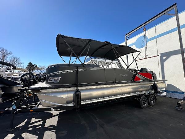 2025 Tahoe Pontoon 2585 LTZ Entertainer with canopy on trailer, parked outdoors.