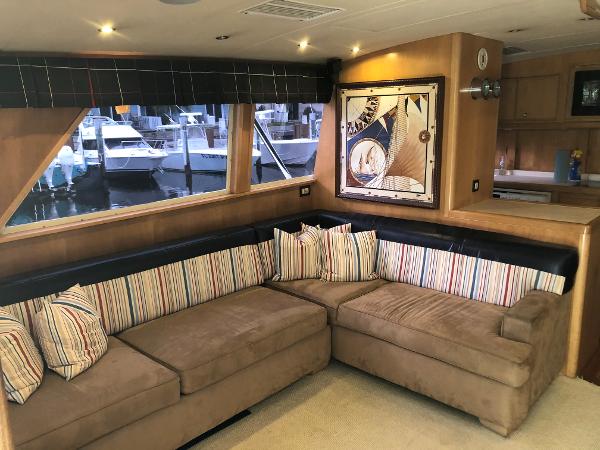 Luxurious interior of a 1997 Bertram Convertible yacht with a cozy sectional sofa.