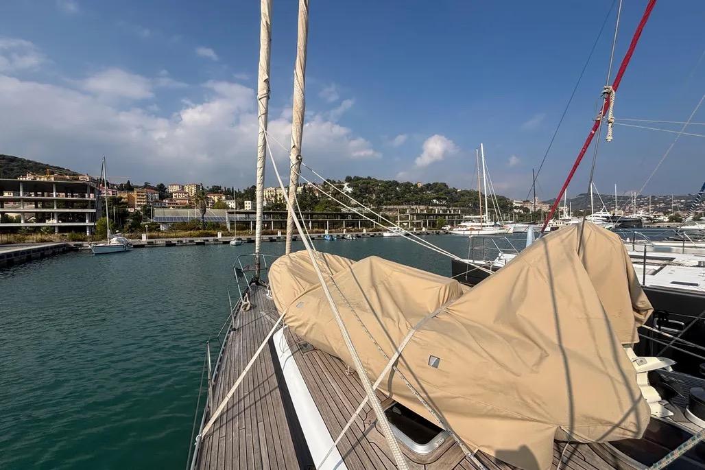 1988 Jongert 2000s yacht docked in a marina, covered sails, clear sky.