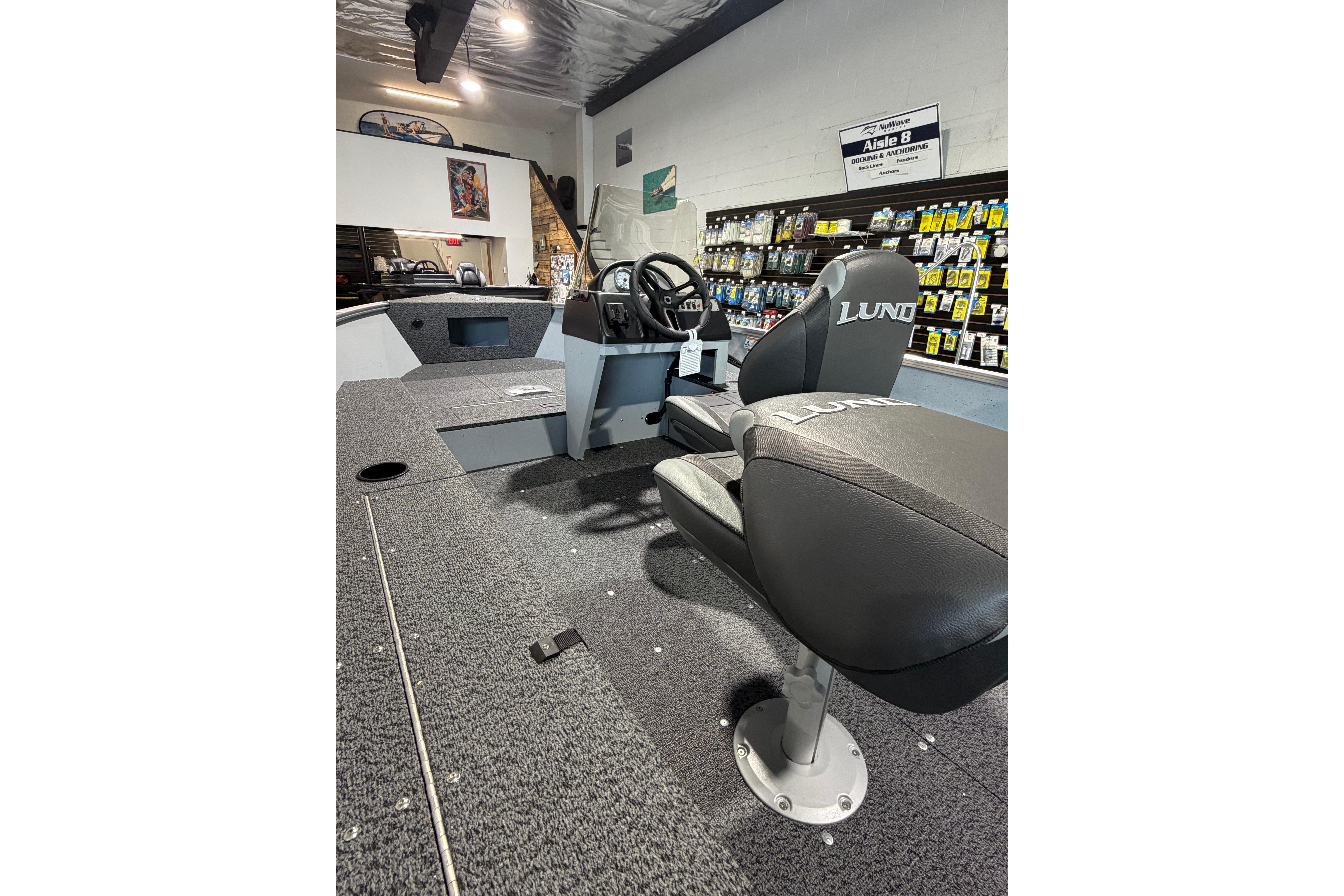 2027 Lund 1600 Fury SS boat interior with steering console and seating in showroom.